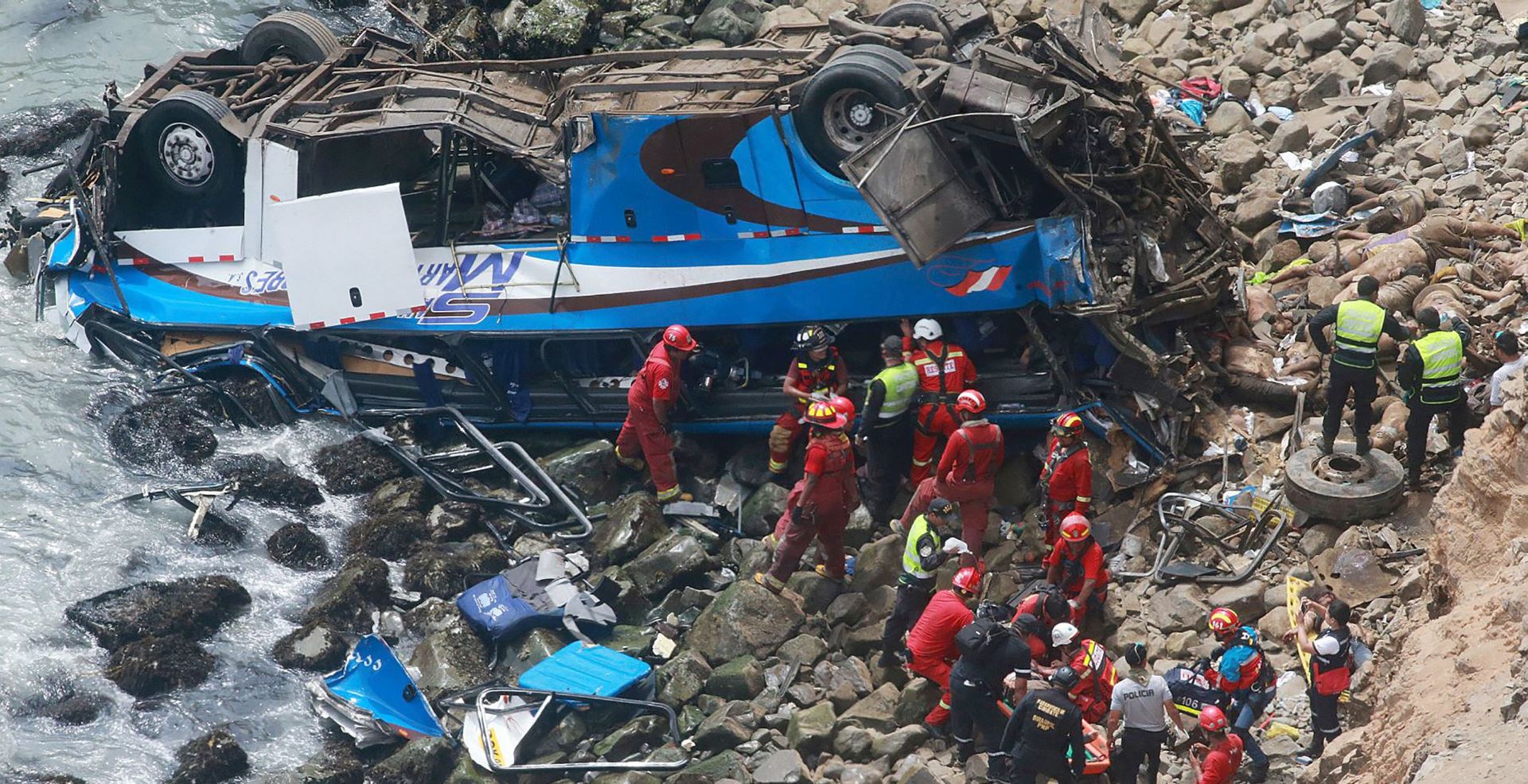 epa06413851 A handout photo made available by Agencia Andina shows a group of emergency personnel  working to rescue victims after a passenger bus plunged off the Pan-American Highway North, about 45 kilometers from Lima, Peru, 02 January 2018. At least 25 people died and 30 injured after a passenger bus plunged off a cliff by the sea in an area known as Pasamayo, in northern Lima, officials said.  EPA/Vidal Tarqui / HANDOUT  HANDOUT EDITORIAL USE ONLY/NO SALES