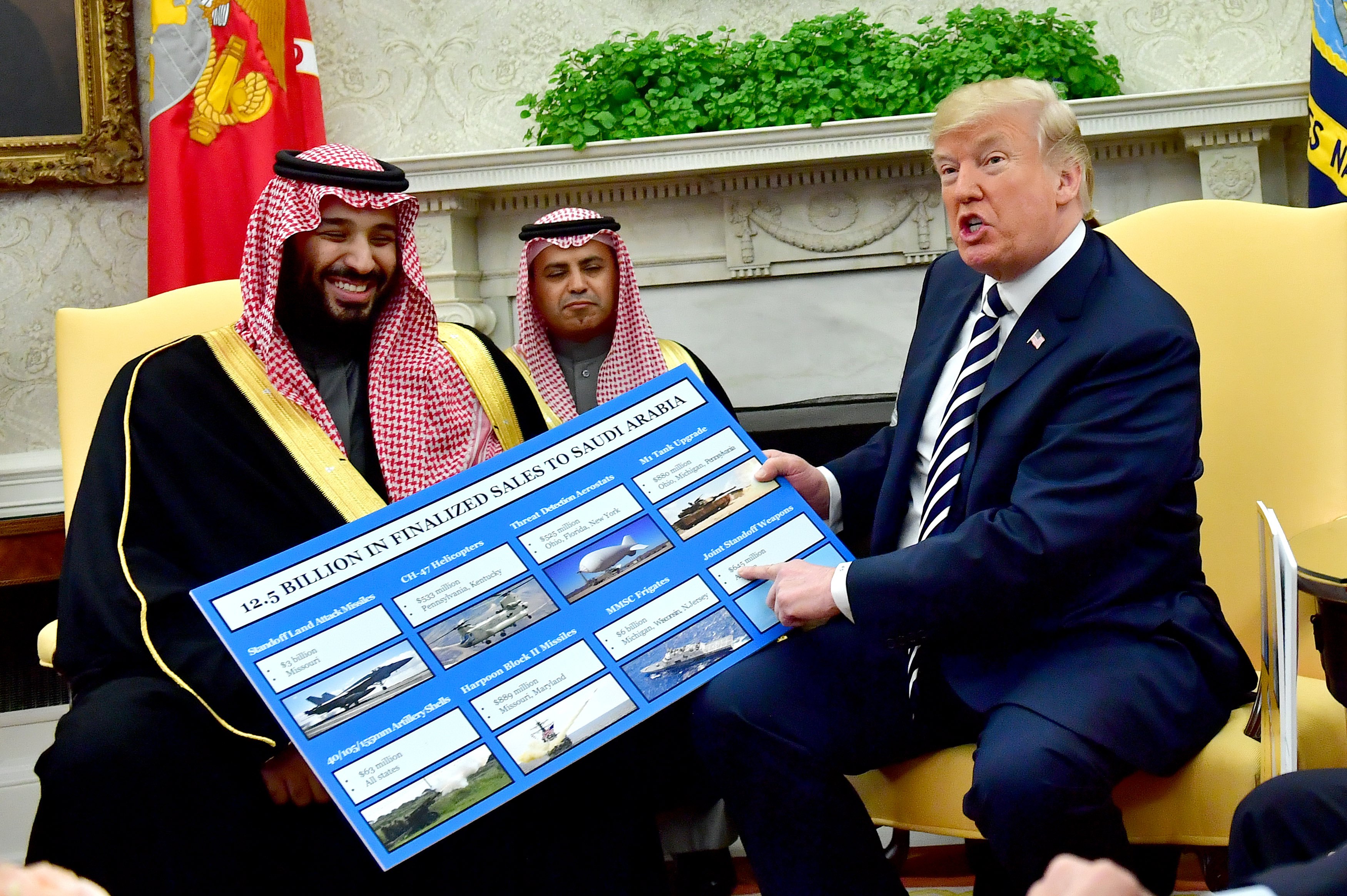 epa06616113 US President Donald J. Trump (R) holds up a chart of military hardware sales as he meets with Crown Prince Mohammed bin Salman (L) of the Kingdom of Saudi Arabia in the Oval Office at the White House in Washington, DC, USA, 20 March 2018.  EPA/KEVIN DIETSCH / POOL