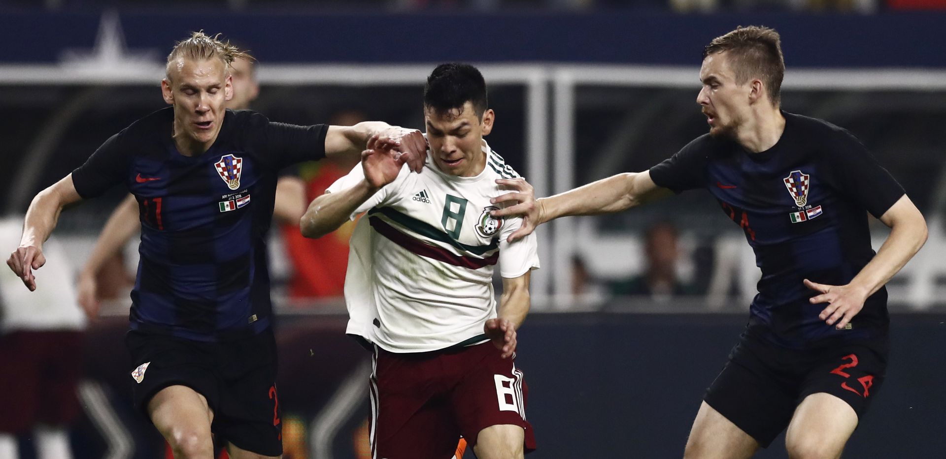 epa06633467 Hirving Lozano (C) of Mexico goes for the ball against Filip Bradaric (R) and Domagoj Vida (L) of Croatia in the second half of the friendly soccer match between Mexico and Croatia in Arlington, Texas, USA, 27 March 2018.  EPA/LARRY W. SMITH