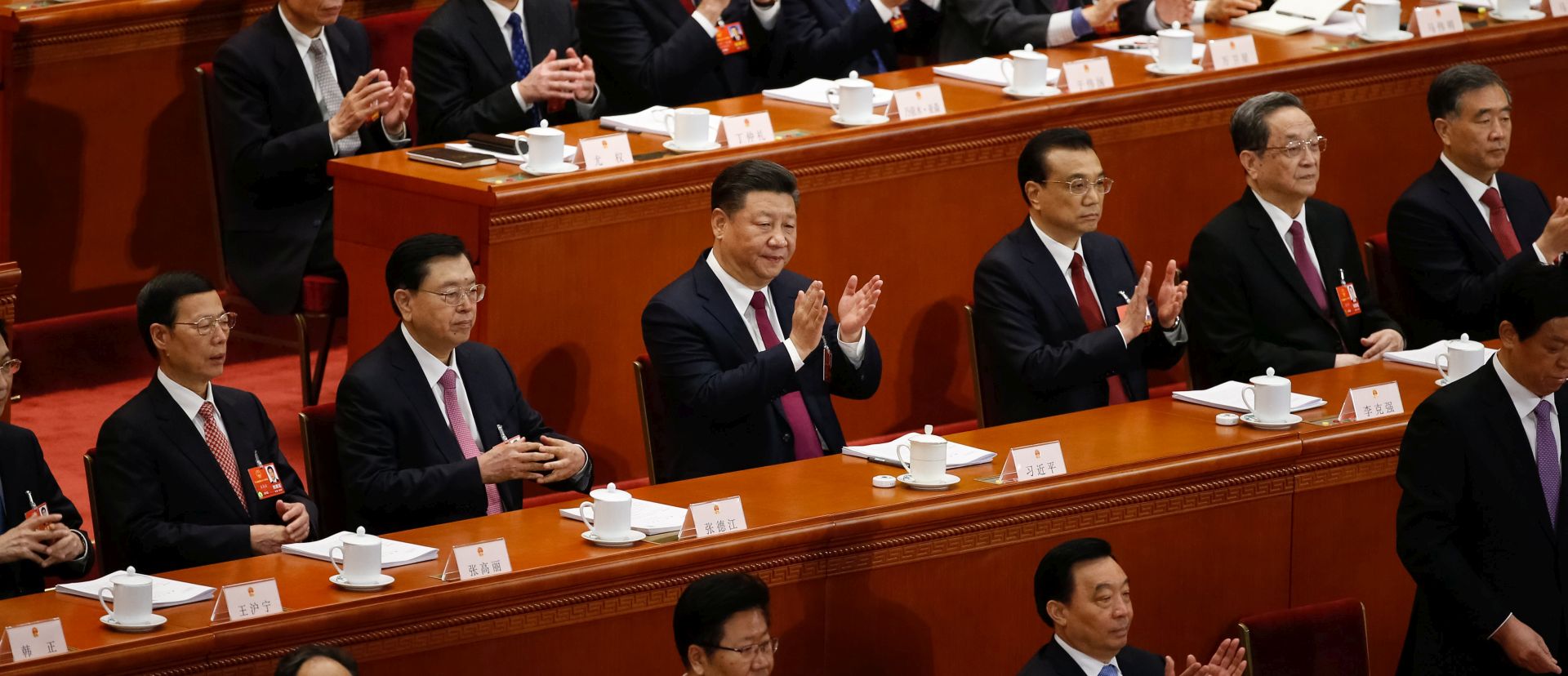 epa06580796 Chinese President Xi Jinping (C-L) and Chinese Premier Li Keqiang (C-R) with other delegates clap during the opening of the first Plenary Session of the 13th National People's Congress (NPC) at the Great Hall of the People (GHOP) in Beijing, China, 05 March 2018. The NPC has over 3,000 delegates and is the world's largest parliament or legislative assembly though its function is largely as a formal seal of approval for the policies fixed by the leaders of the Chinese Communist Party. The NPC runs alongside the annual plenary meetings of the Chinese People's Political Consultative Conference (CPPCC), together known as 'Lianghui' or 'Two Meetings'.  EPA/ROMAN PILIPEY