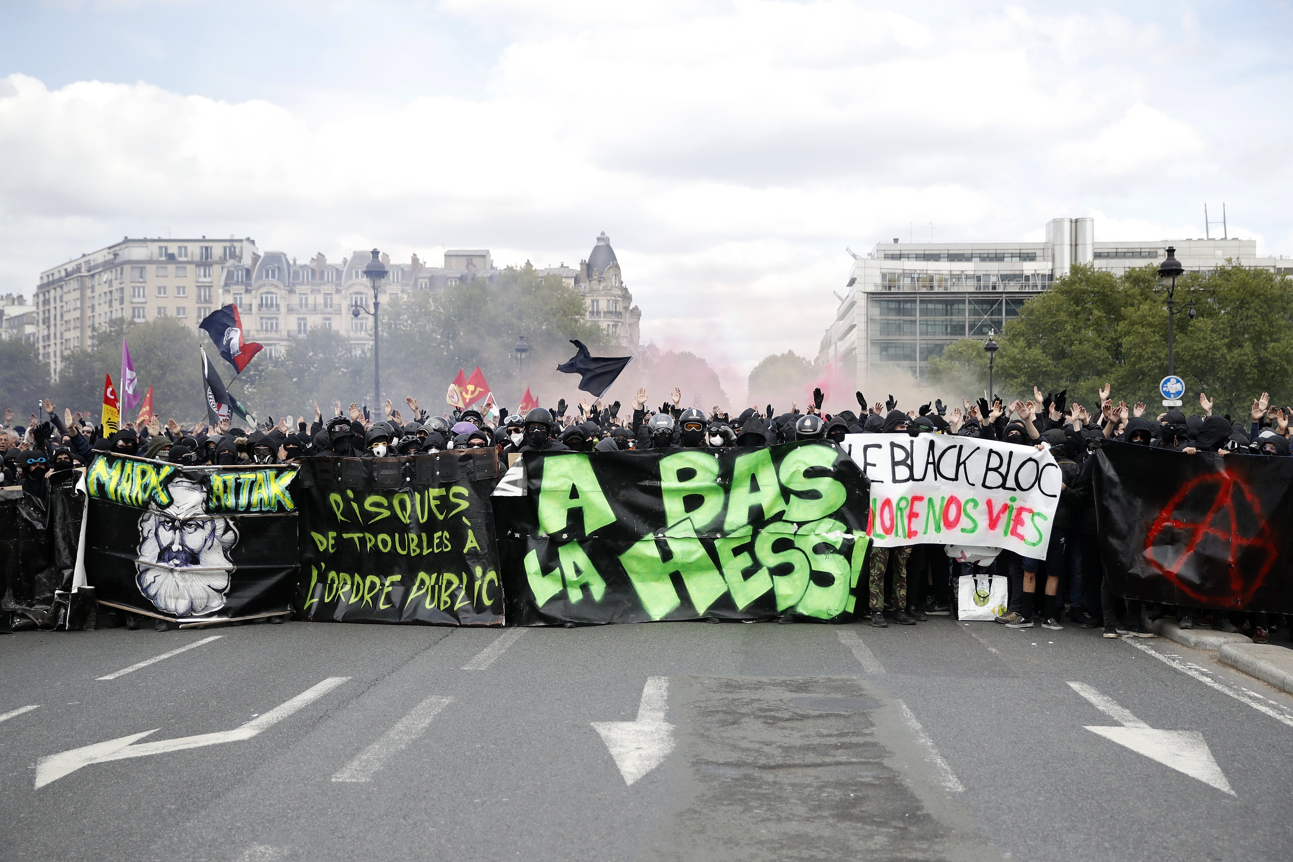 epa06704986 Masked youth protesterswith banners and placards block a road ahead of clashes with French police forces during a demonstration of workers from the private and public sectors as well as labor unions on the occasion of the annual May Day marches on the International Workers' Day, in Paris, France, 01 May 2018. French unions led a movement of strikes to protest against government reforms in the public services.  EPA/YOAN VALAT