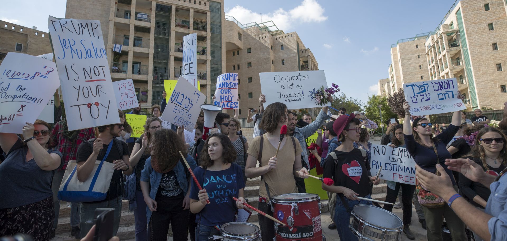 epa06736271 Israeli activists and Palestinians hold banners during a protest outside of the US embassy in Jerusalem, during the official inauguration ceremony, 14 May 2018. The US Embassy in Jerusalem is inaugurated on 14 May following its controversial move from Tel Aviv to the existing US consulate building in Jerusalem. US President Trump in December 2017 recognized Jerusalem as Israel's capital. The decision, condemned by Palestinians who claim East Jerusalem as the capital of a future state, prompted worldwide protests and was met with widespread international criticism.  EPA/ATEF SAFADI