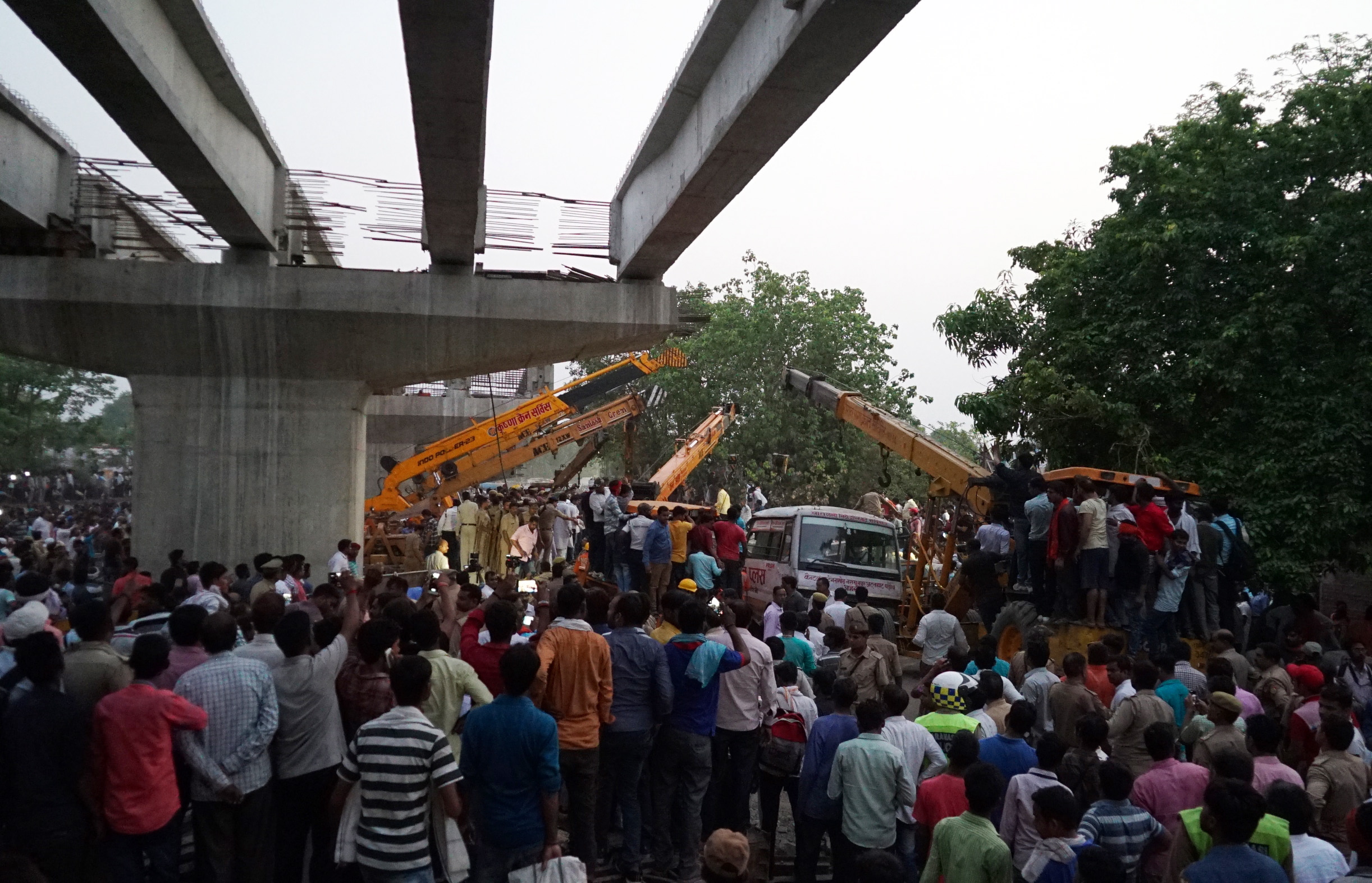 epa06739079 People gather as workers are engaged in rescue work at the spot where a portion of an under construction bridge collapsed in Varanasi, India, 15 May 2018. At least 12 people are killed and many others are still trapped after the bridge collapsed near a railway station.  EPA/PRABHAT KUMAR VERMA