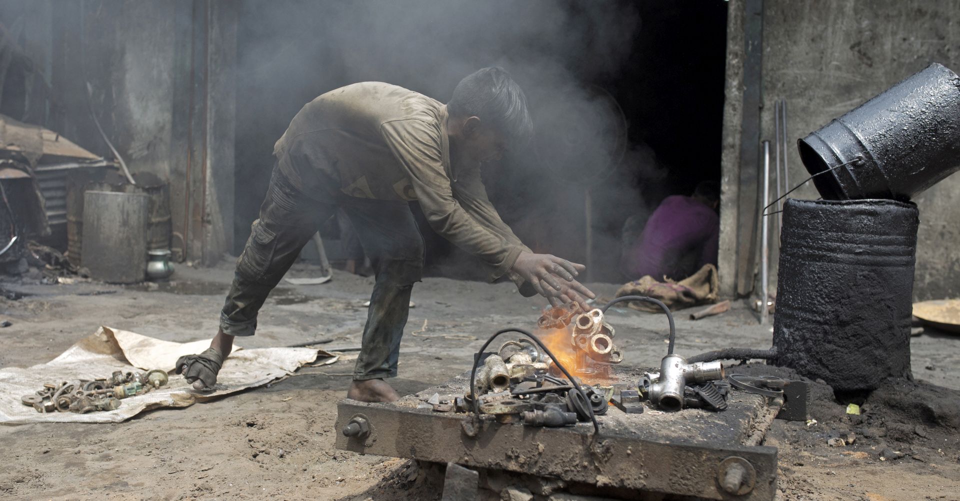 epa06802053 Ten-years old Sayed works without any safety gear as he melts scrap metal in a dockyard workshop in Keraniganj, Dhaka, Bangladesh, on World Day Against Child Labour (WDACL), 12 May 2018. The theme of this year's the World Day Against Child Labor (WDACL) and the World Day for Safety and Health at Work (Safe Day) shines 'a spotlight on the global need to improve the safe and health of young workers and end child labour' as the International Labour Organization (ILO) announced on their website.  EPA/MONIRUL ALAM