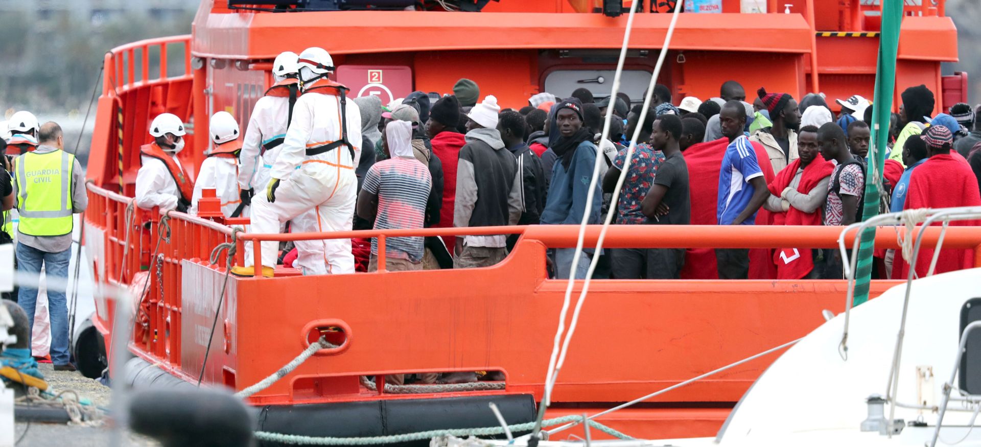 epa06818113 Spanish Civil Guards, National policemen and Red Cross volunteers help migrants to disembark from a rescue ship upon their arrival to the port of Arguineguin in Gran Canaria, Canary islands, Spain, 18 June 2018. A total of 152 migrants traveling on board a small boat were rescued 17 June night about 410 kilometers away from the Canarias.  EPA/ELVIRA URQUIJO A.