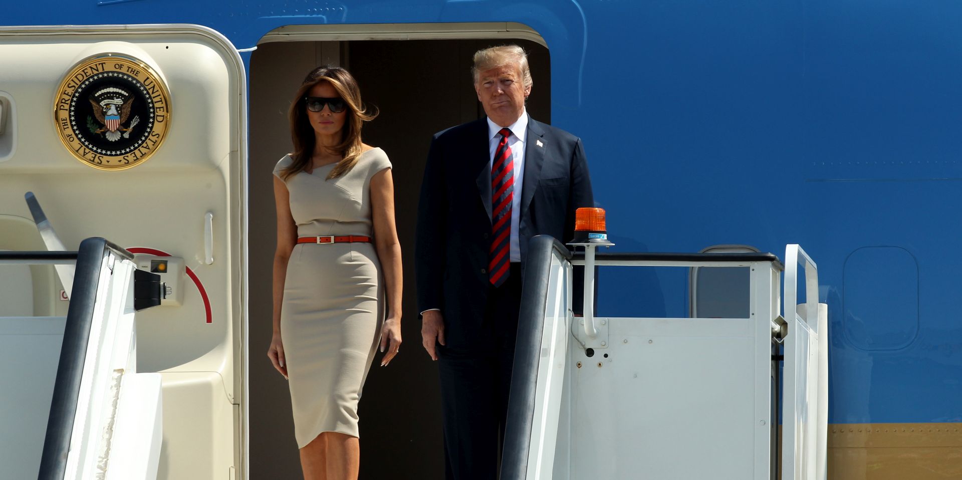 epa06883748 US President Donald J. Trump (R) and his wife Melania Trump (L) walk down from their plane as they arrive for their first offical visit to the UK at the London Stansted Airport in Essex, Britain, 12 July 2018. US President Trump is on a three-day working visit to the United Kingdom.  EPA/SEAN DEMPSEY