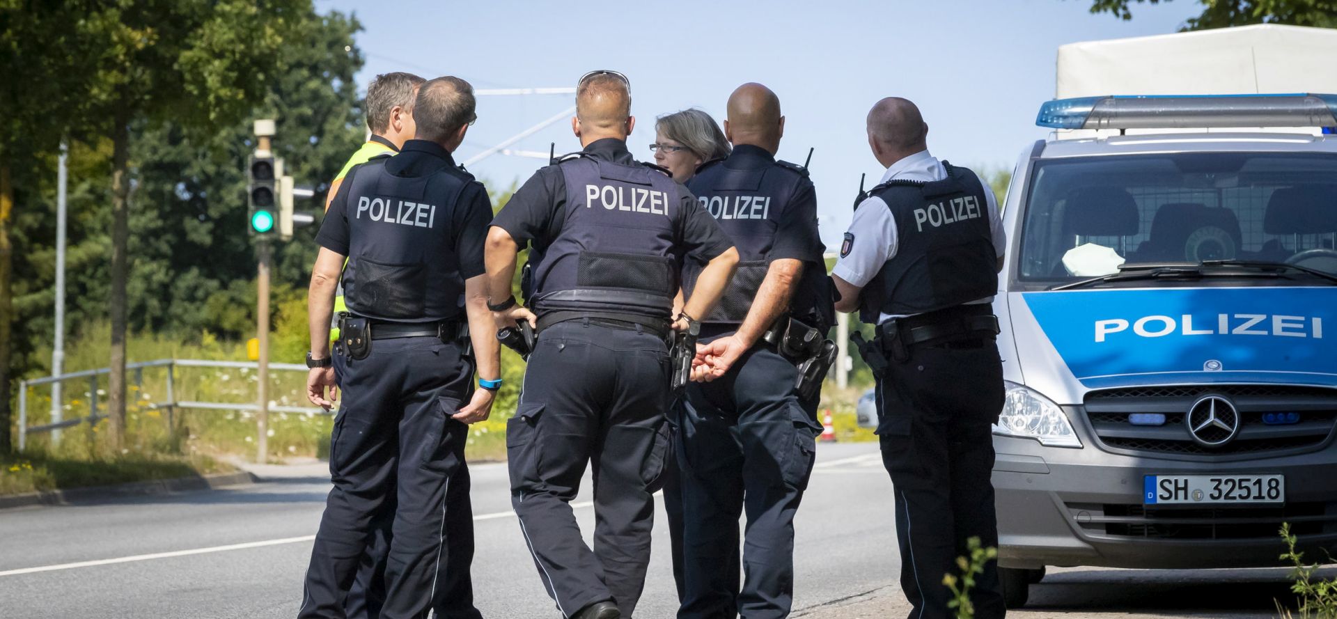 epa06900732 Policemen near the scene where a person had allegedly attacked passengers on a bus in Luebeck, Germany, 20 July 2018. According to police reports, several people were injured in a violent incident in a bus in Luebeck Kuecknitz. The perpetrator has been arrested, police said.  EPA/FELIX KOENIG