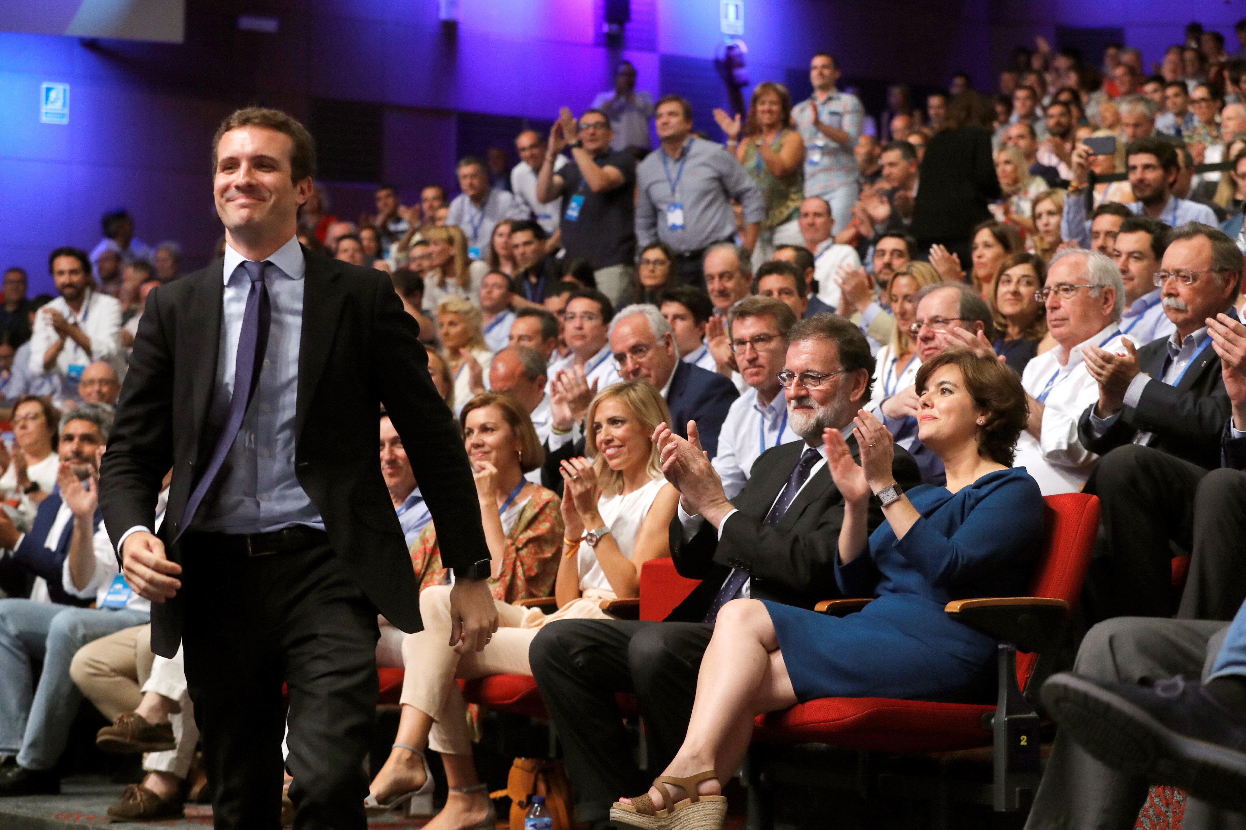 epa06902553 Newly-elected leader of the Spanish conservative People's Party (PP), Pablo Casado (L), reacts during the People's Party (PP) national congress in Madrid, Spain, 21 July 2018. Casado and former deputy Prime Minister Soraya Saenz de Santamaria (R, seated) were both contenders to take over the party's chair from former Prime Minister and outgoing party leader Mariano Rajoy 2-R, seated).  Media reports state that Casado, 37, received a majority of 57 percent of the delegates' votes, while Saenz de Santamaria, gained some 42 percent of the votes of the PP delegates. Others are not identified.  EPA/JUAN CARLOS HIDALGO