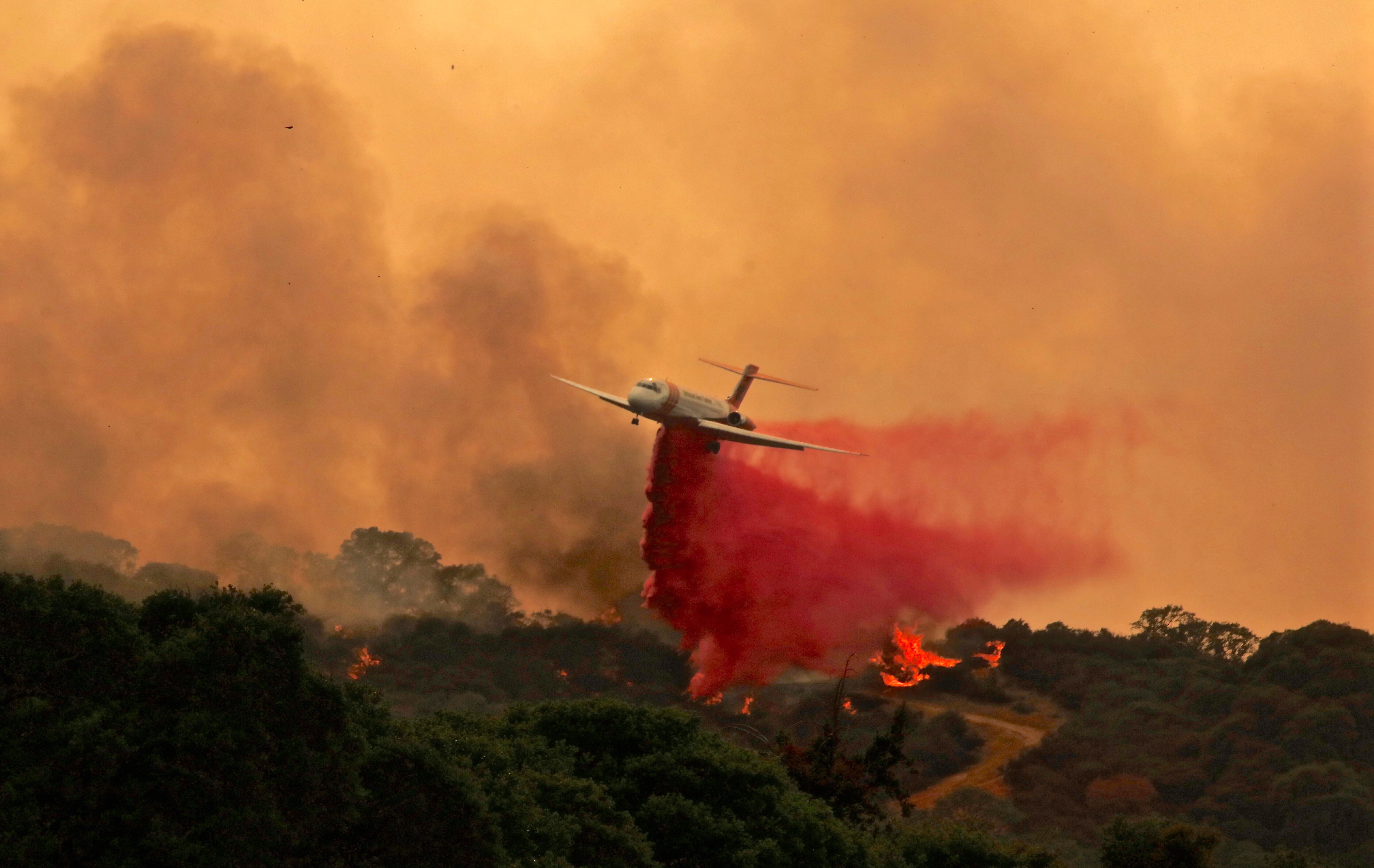 epa06919522 A firefighting plane makes a retardant drop on the River Fire portion of the Mendocino Complex Fire in Lakeport, California, USA, 29 July 2018 (issued 30 July 2018). The River and Ranch fires combined as the Mendocino Complex Fire with more than 56,000 acres (22,660 hectares) burned, nearly doubling since Sunday with more than 10,000 people already evacuated.  EPA/ALAN SIMMONS