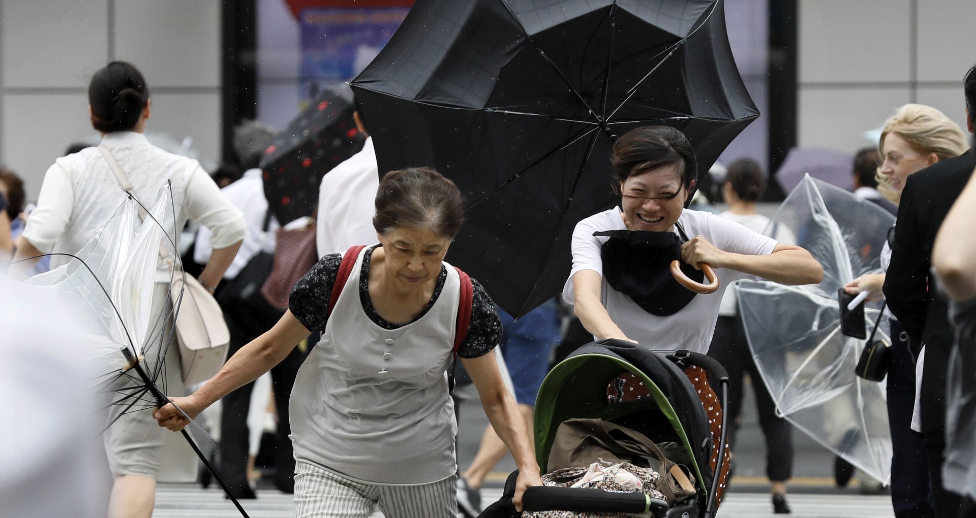 epa06995533 Pedestrians using umbrellas struggle against strong wind and rain in Tokyo, Japan, 04 September 2018. Powerful Typhoon Jebi, the 21st typhoon of the season, has made landfall on Shikoku Island and western Japan, bringing strong winds, high waves and heavy rains.  EPA/KIMIMASA MAYAMA