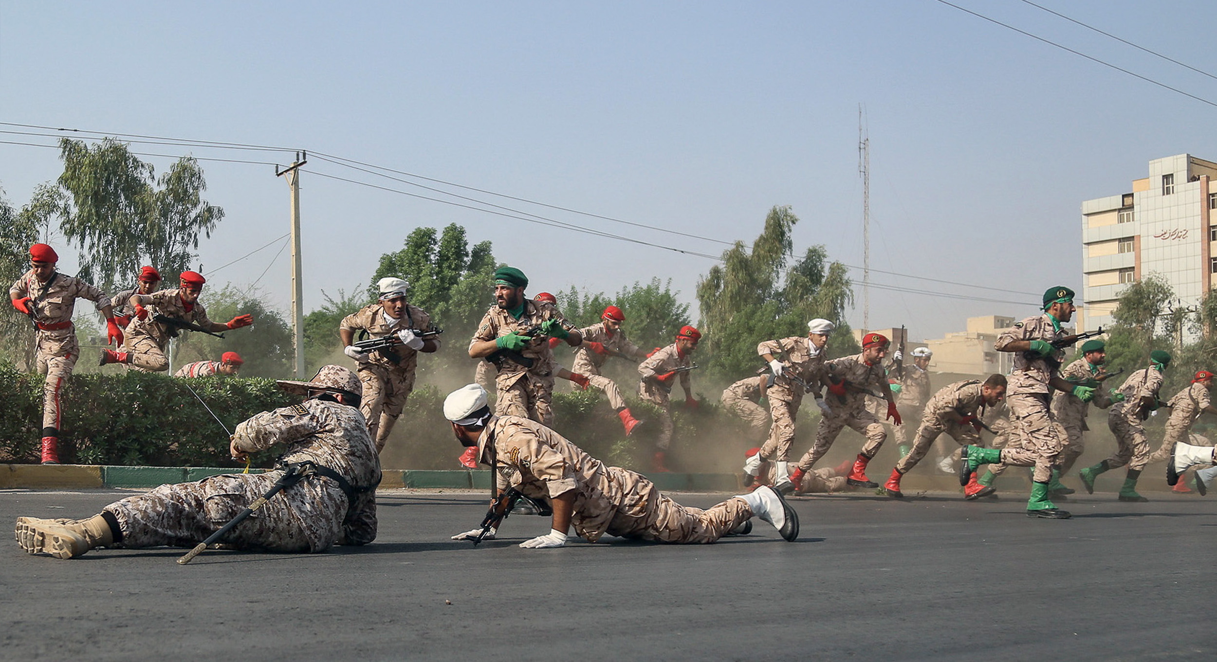 epa07039277 Iranian soldiers jump over a hedge at a street as they run for cover during a terror attack that occurred during a military parade in the city of Ahvaz, southwest Iran, 22 September 2018. According to media reports, gunmen have opened fire during an Iranian military parade in the south-western city of Ahvaz, killing at least 25 people, including civilians, and injuring dozens.  EPA/MORTEZA JABERIAN