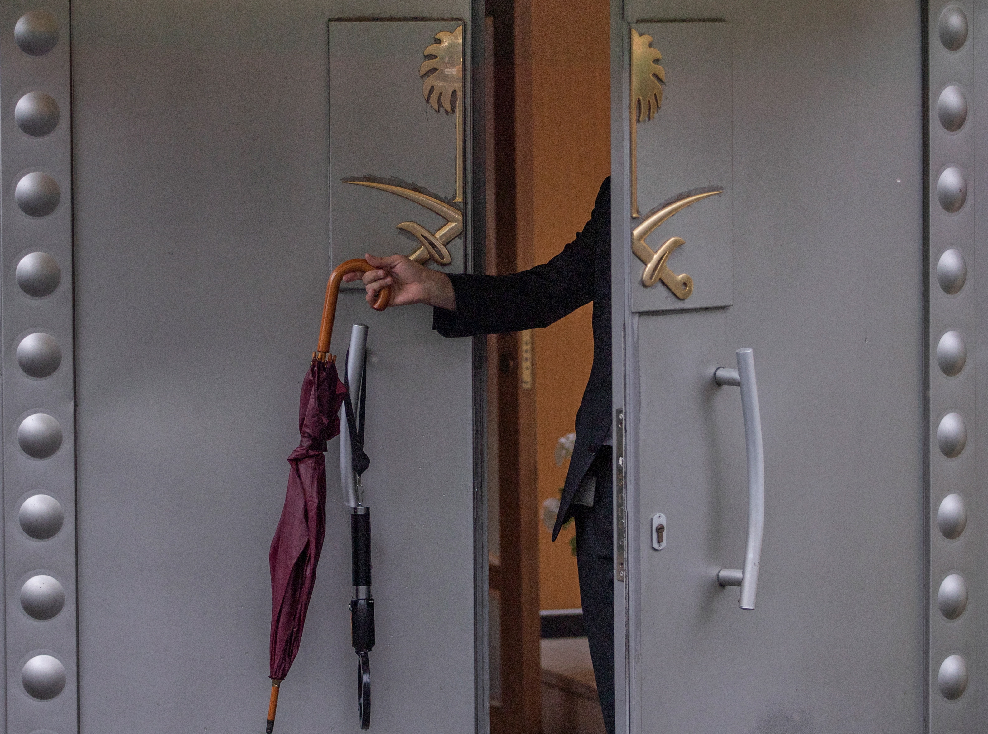 epa07085060 An official hangs an umbrella on a door of the Saudi consulate in Istanbul, Turkey, 11 October 2018. Turkish President Recep Tayyip Erdogan on 07 October said he is following the developments on the disappearance of Saudi journalist Jamal Khashoggi who has gone missing after visiting the Saudi consulate in Istanbul on 02 October to complete routine paperwork.  EPA/SEDAT SUNA