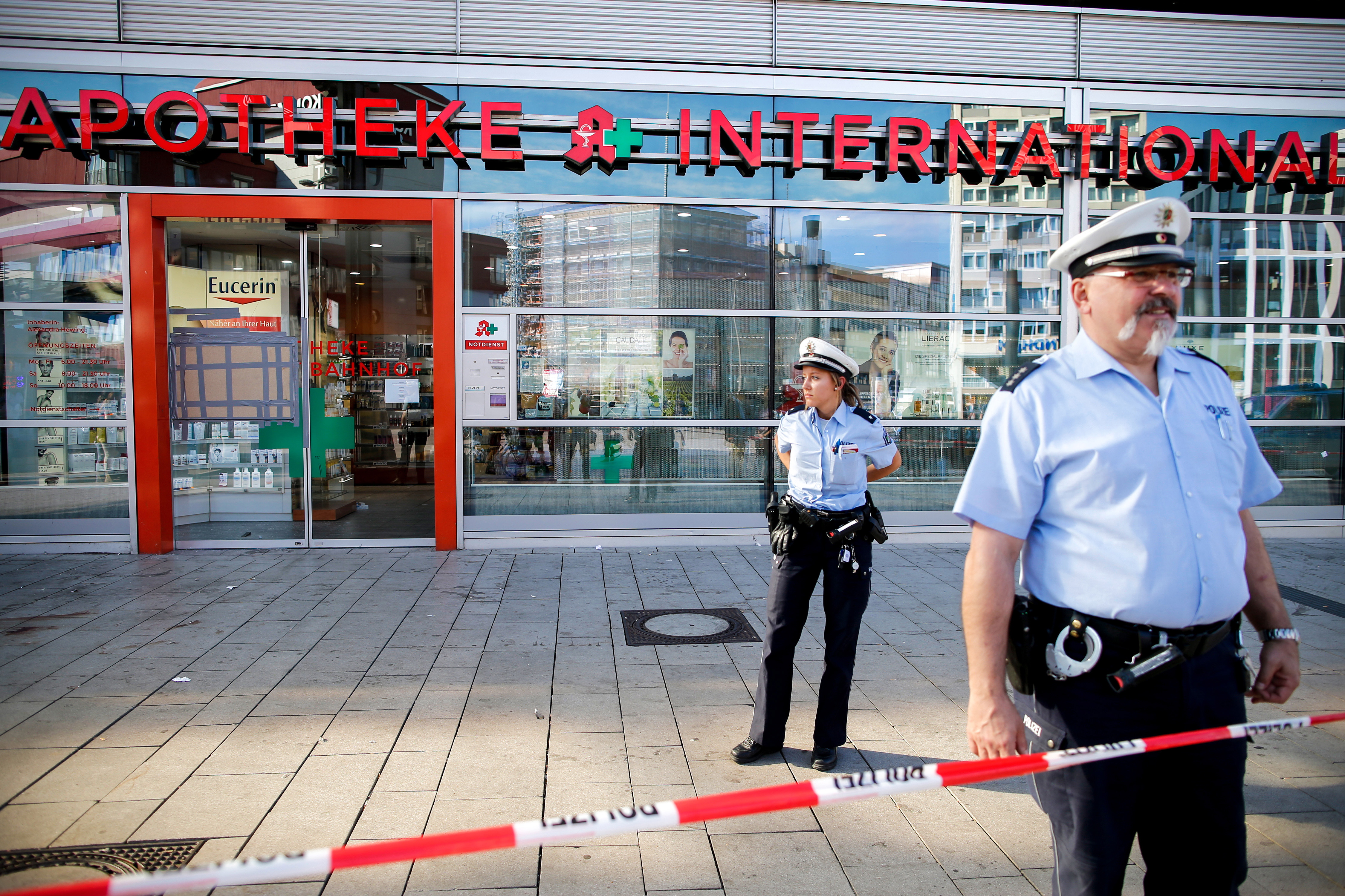 epa07096934 Police officers stand guard in front of a pharmacy at the Central Station in Cologne, Germany, 16 October 2018. Police are investigating a terrorist background after a hostage-taking at Cologne's Main Station on 15 October 2018, in which the hostage-taker was shot down by special forces and seriously injured.  EPA/SASCHA STEINBACH