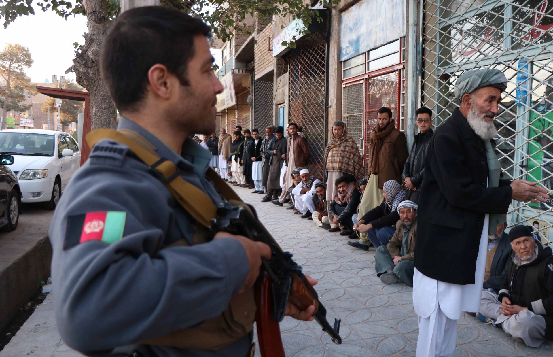 epa07106072 Afghans wait outside a polling station to cast their ballot during parliamentary elections in Herat, Afghanistan, 20 October 2018. The Taliban on 19 October threatened to boycott the upcoming parliamentary elections in Afghanistan and block roads in the country. More than 2,500 candidates are contesting in 249 seats in the Afghan parliament.  EPA/JALIL REZAYEE