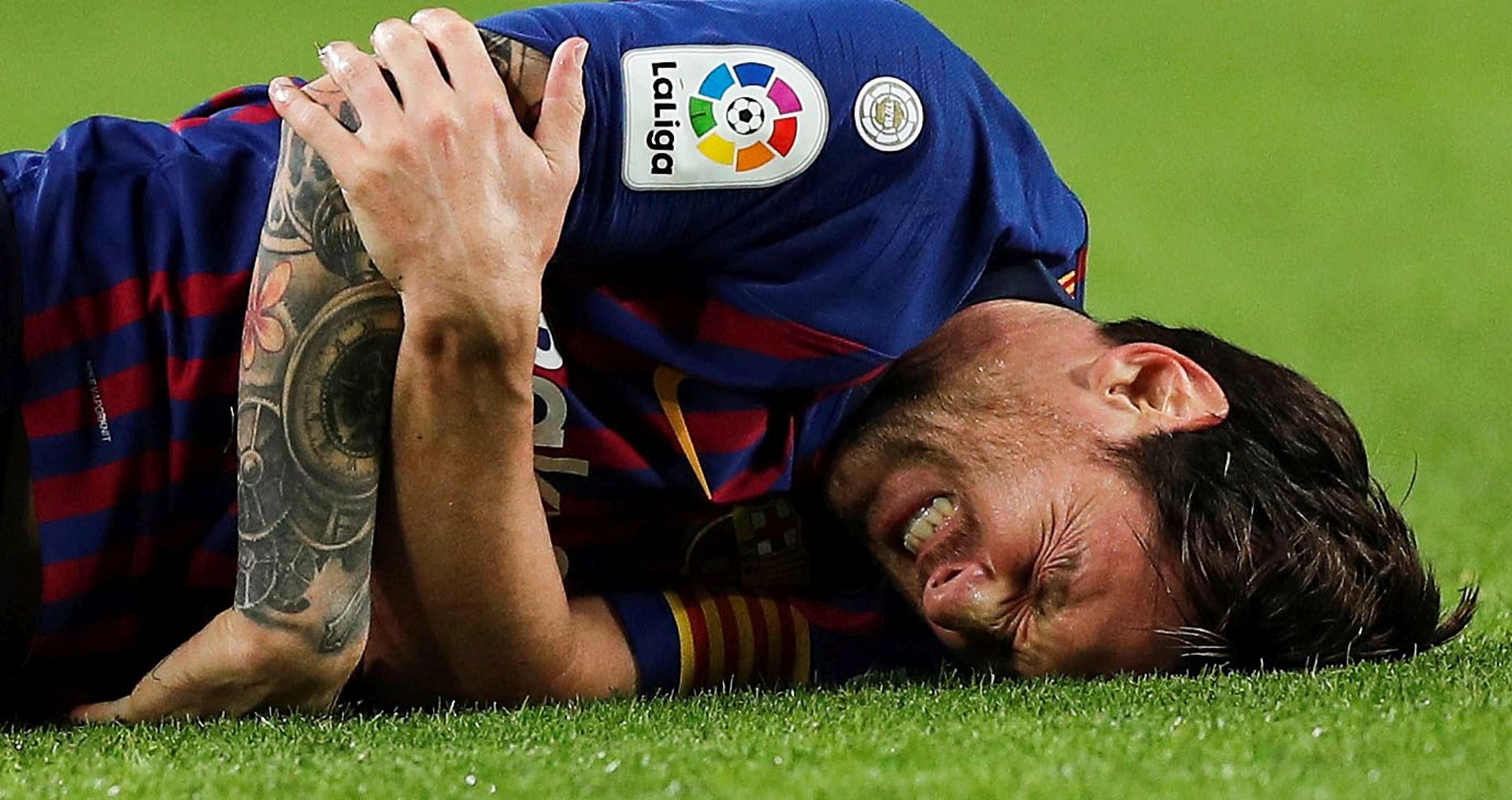 epa07108758 FC Barcelona's Argentinian striker Lionel Messi lies on the pitch after injuring his right elbow during their Spanish Liga Primera Division soccer match against Sevilla CF played at Camp Nou stadium in Barcelona, Spain, 20 October 2018 (issued on 21 October).  EPA/Alejandro Garcia