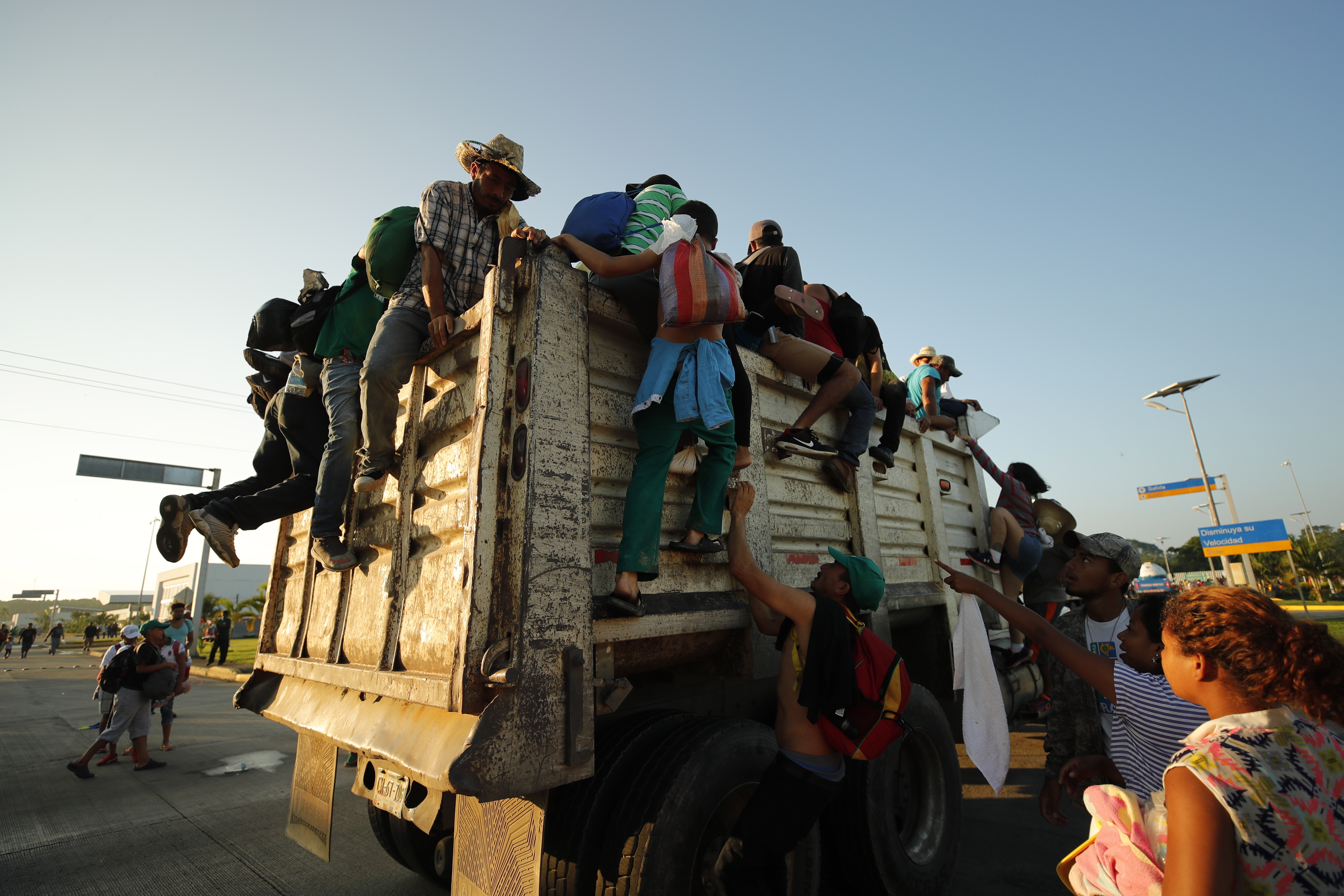 epa07116442 Honduras migrants climb onto a truck as they begin another day of traveling toward to USA from town of Huixtla, Chiapas state, Mexico, 24 October 2018. Thanks to their faith in God and despite his harsh rhetoric, the migrants believe that the president of the United States, Donald Trump, will allow the entrance of the Central American caravan to the United States. More than 7,000 people are part of the caravan of Central American migrants that is heading towards the United States, according to a recent estimate released by the United Nations.  EPA/JOSE MENDEZ
