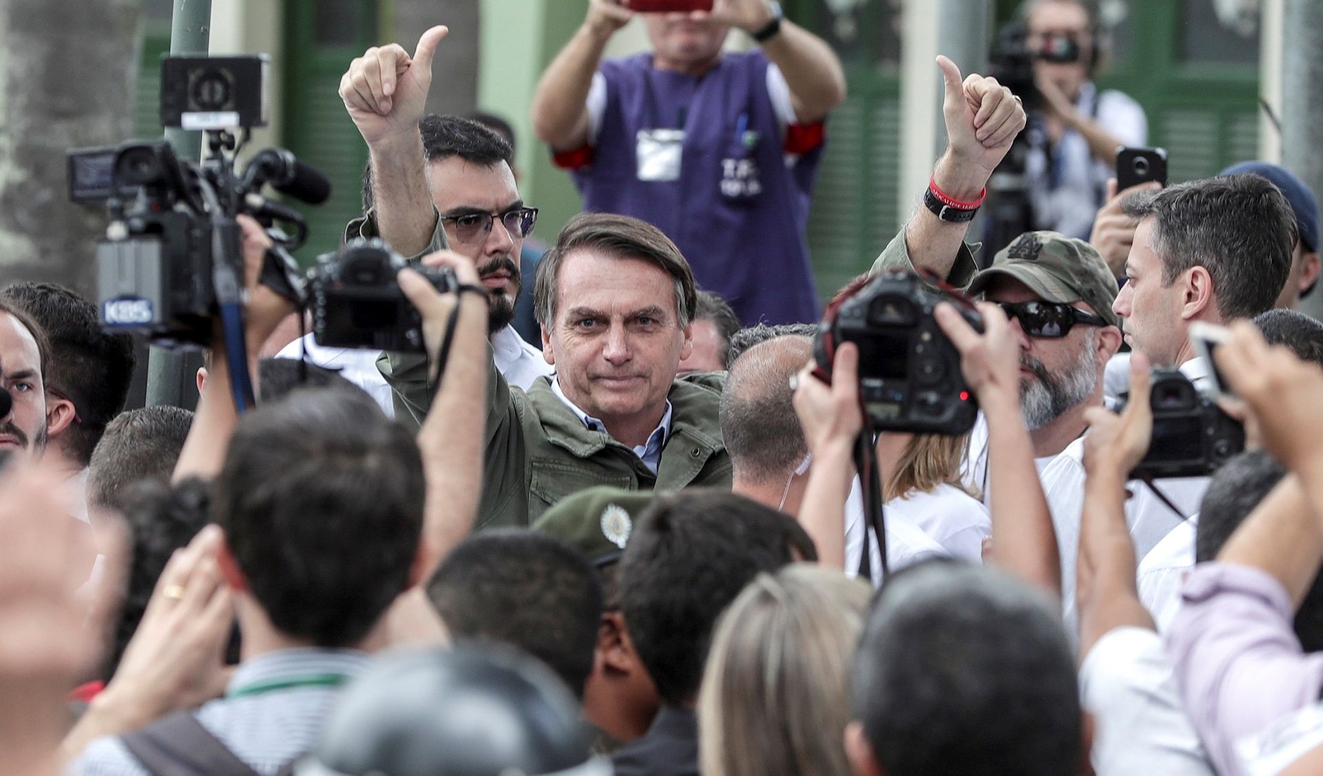epa07126574 Far-right candidate Jair Bolsonaro (C) of the Social Liberal Party (PSL) gives 'thumb up' to supporters after voting at a polling station in Rio de Janeiro, Brazil, 28 October 2018. Brazilians are called to vote in the second round of the country's presidential elections, where far-right candidate Jair Bolsonaro is favorite to win in all surveys. Fernando Haddad of the Workers Party will face Jair Bolsonaro, of the Social Liberal Party (PSL) in the second round of voting.  EPA/ANTONIO LACERDA
