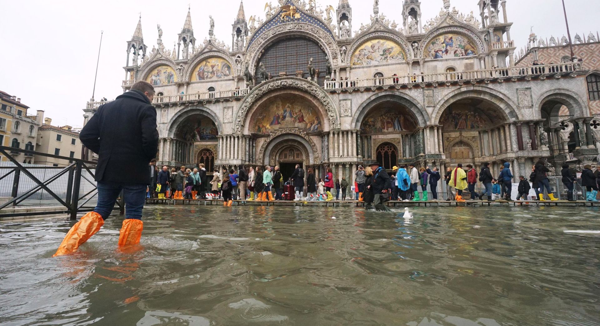 epa07135182 A tourist wanders in high water at the San Marco Square in Venice, northern Italy, 01 November 2018. The tide reached some 120 centimeters above the sea level.  EPA/ANDREA MEROLA