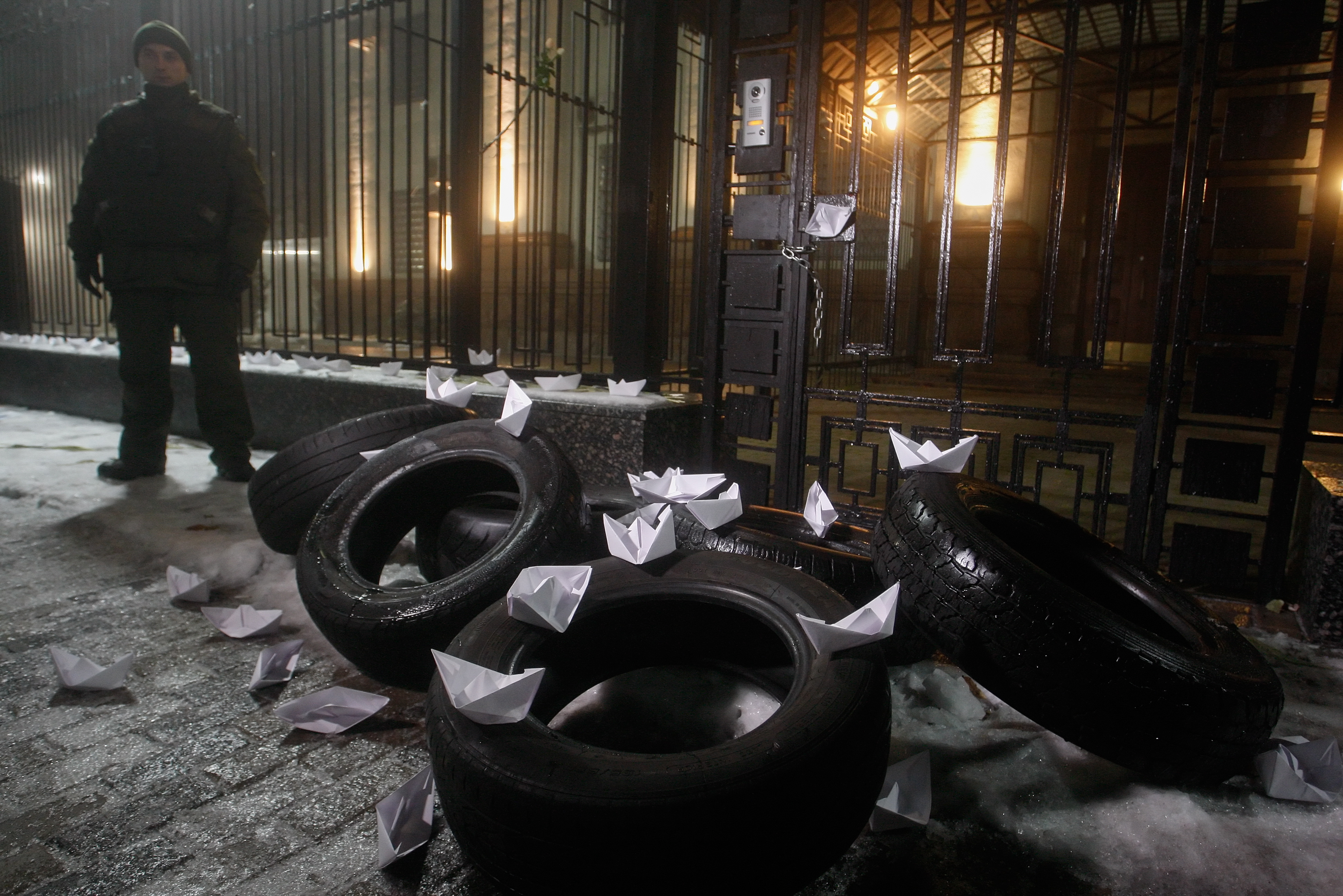 epa07190224 Protestors set up paper ships on the tires during their rally near of Russian embassy building  in Kiev, Ukraine, 25 November 2018. Russia has seized three Ukrainian vessels amid their leaving the Kerch Strait; Ukrainian President Petro Poroshenko is gathering the Military Cabinet over the incident. The two small-sized 'Berdiansk' and 'Nikopol' armored artillery boats have come under enemy fire and are now dead in the water. The 'Yany Kapu' tugboat has forcibly been stopped. The vessels have been captured by special forces of the Russian Federation, the press service of Ukraine's Navy said on Facebook on Sunday evening. The Ukrainian Navy also reported the number of the Ukrainian servicemen wounded in the incident grew to two persons as Ukrainian media report.  EPA/STEPAN FRANKO  EPA-EFE/STEPAN FRANKO