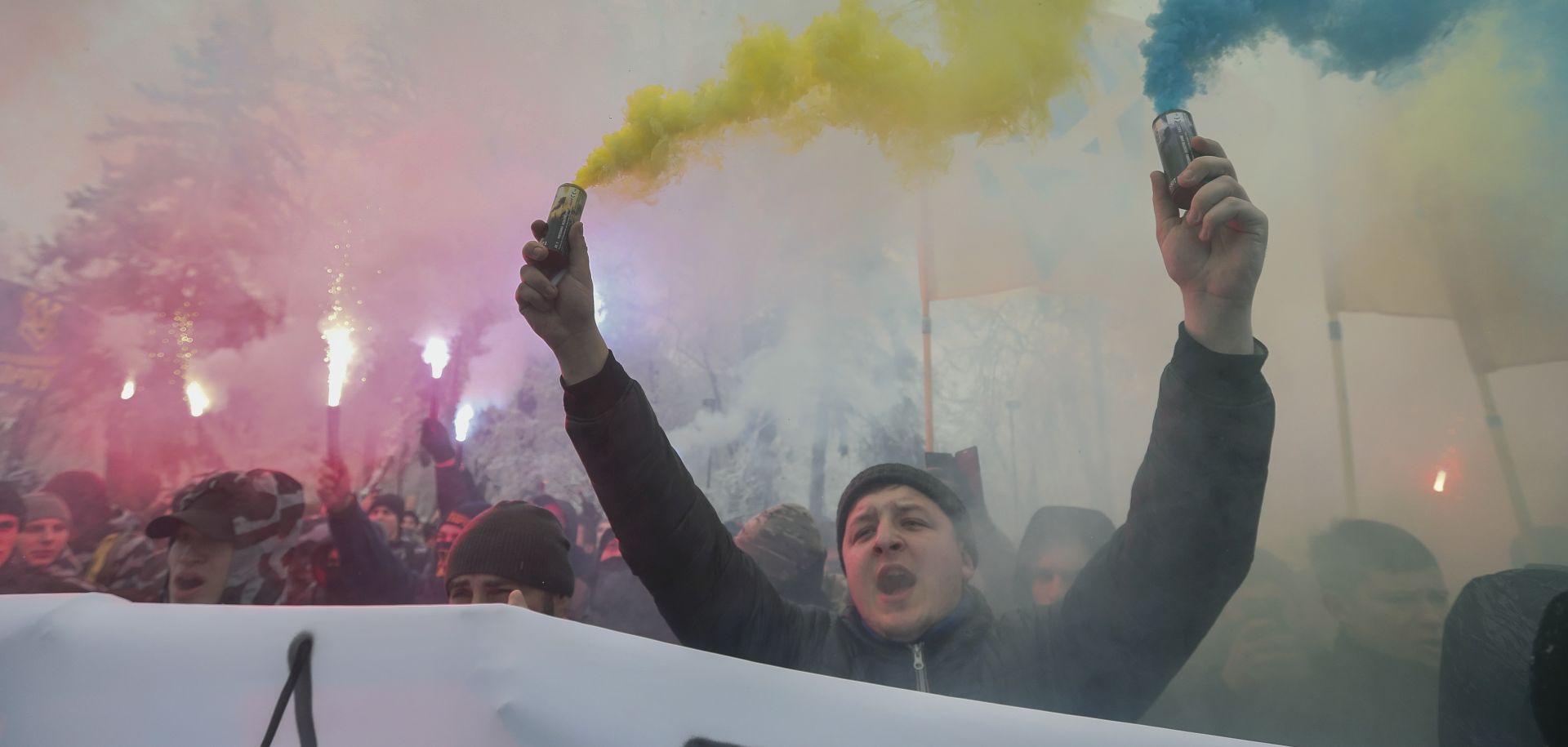 epa07190805 Ukrainian Nationalists burn flares and smoke grenades during their rally in front of Parliament building in Kiev, Ukraine, 26 November 2018 as they demand to break the diplomatic relations with Russia and nationalization of Russian property in Ukraine. The President of Ukraine Petro Poroshenko at a meeting of the National Security and Defense Council on 25 November 2018 announced the decision to introduce martial law in Ukraine and to appeal to the Parliament to consider the move at an extraordinary meeting. It is about the introduction of martial law for a period of 60 days. The Ukrainian Parliament will convene for an extraordinary meeting at evening 26 November 2018. Russia has seized three Ukrainian vessels amid their leaving the Kerch Strait on 25 November 2018. The two small-sized 'Berdiansk' and 'Nikopol' armored artillery boats have come under enemy fire and are now dead in the water. The 'Yany Kapu' tugboat has forcibly been stopped. The vessels have been captured by special forces of the Russian Federation, the press service of Ukraine's Navy said on Facebook on Sunday evening.  EPA/SERGEY DOLZHENKO