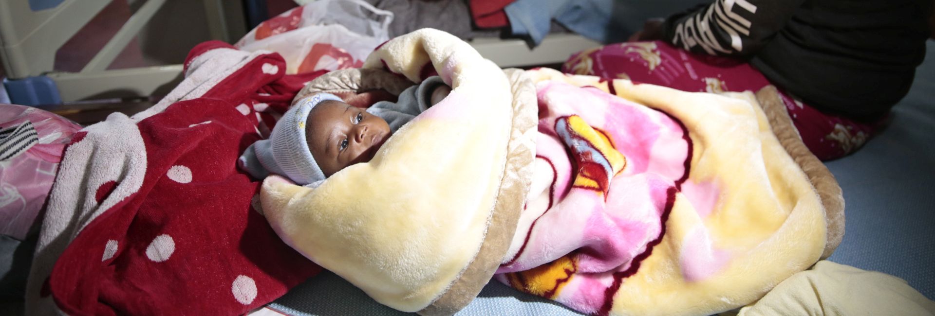 epa07151567 Three month old baby Klavan Munyisa (front) escaped without any injuries while her mother behind was slightly injured and is treated in the Rusape General Hospital  after the collision of two long distance buses in Rusape, some 170 kilometers east of the capital Harare, Zimbabwe, on 07 November 2018. Reportedly at least 47 people died and several others were injured in the bus accident.  EPA/AARON UFUMELI