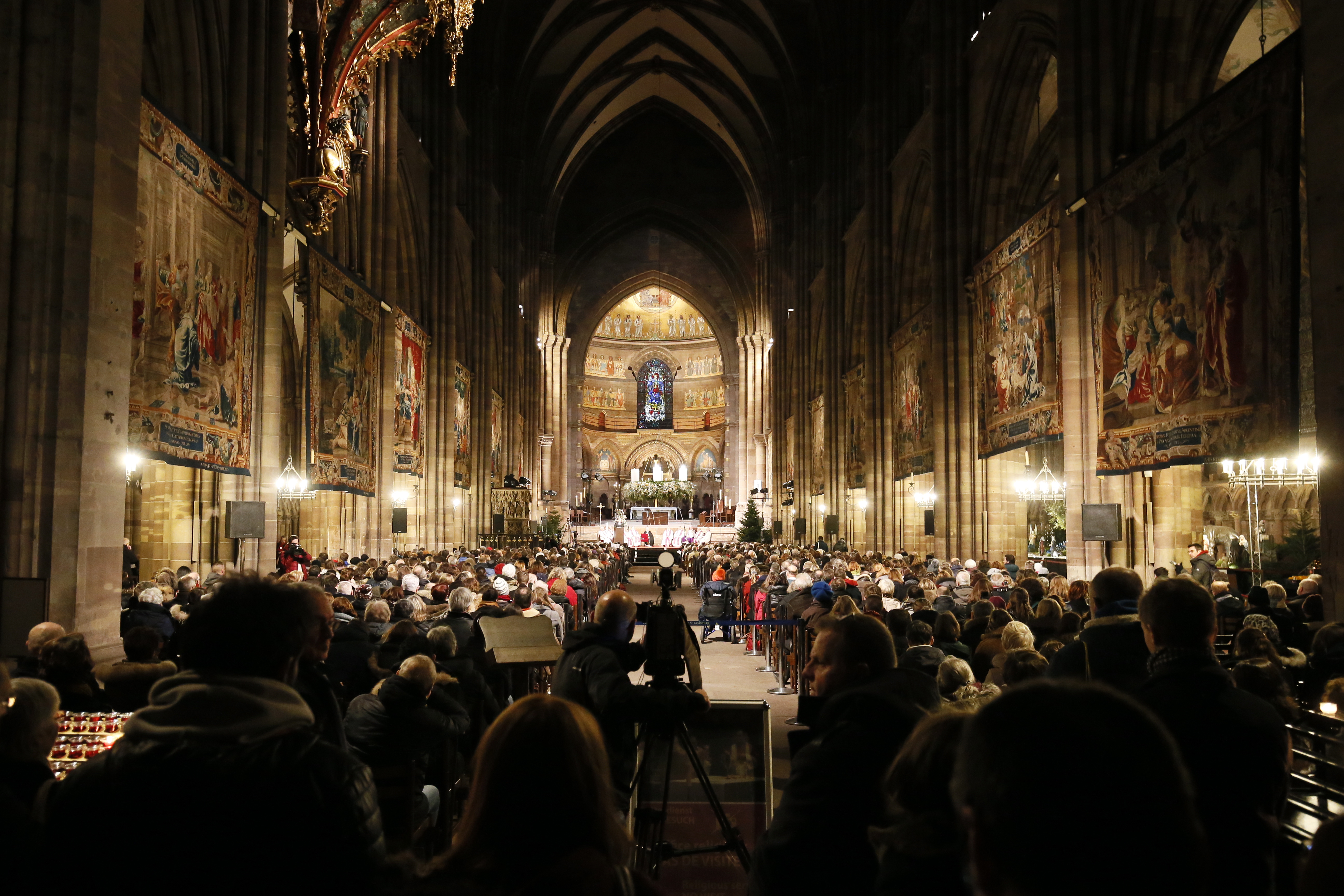 epa07229218 People attend a prayer vigil to honor the victims of the Christmas market attack, held at the Cathedral of Our Lady of Strasbourg, France, 13 December 2018. A manhunt is underway for the suspected perpetrator of the attack, Cherif Chekatt.  EPA/RONALD WITTEK