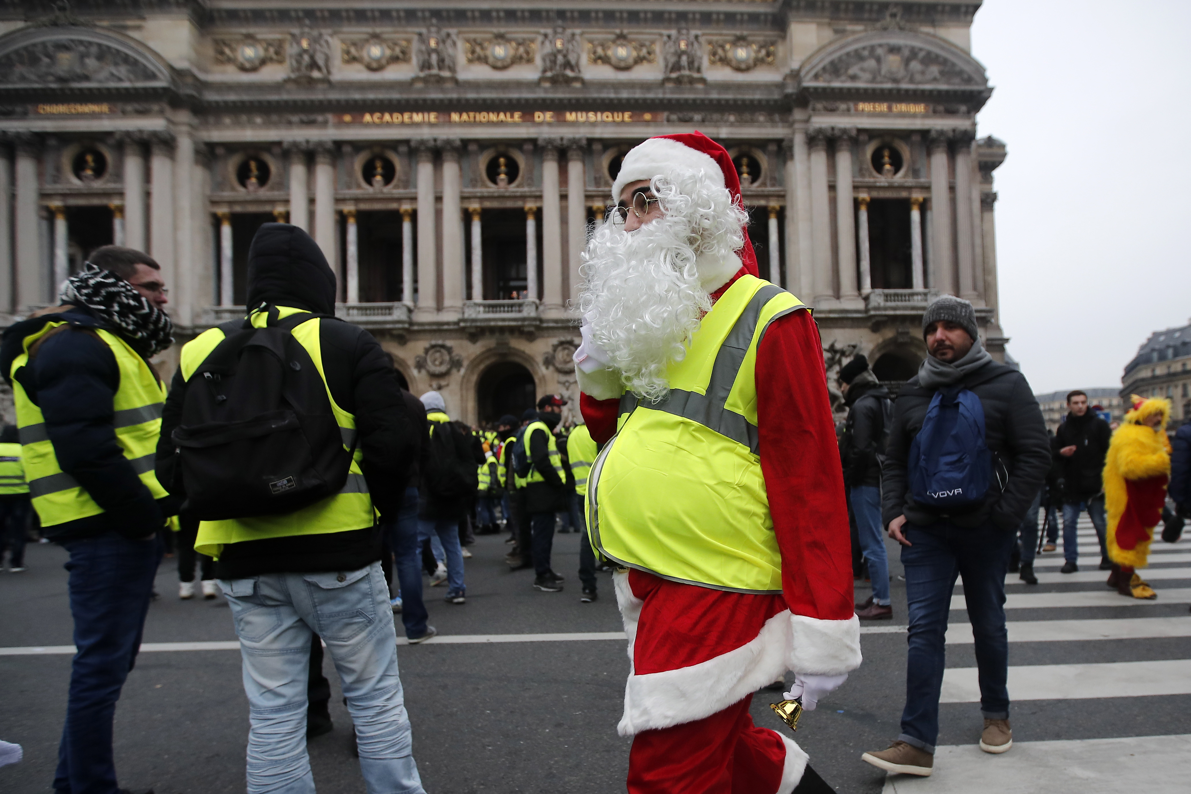 epa07232362 A Yellow Vest protestor wearing a Santa Claus outfit attends a demonstration in front of the Opera in Paris, France, 15 December 2018. The so-called 'gilets jaunes' (yellow vests) is a protest movement, which reportedly has no political affiliation, that continues protests across the nation over high fuel prices.  EPA/IAN LANGSDON