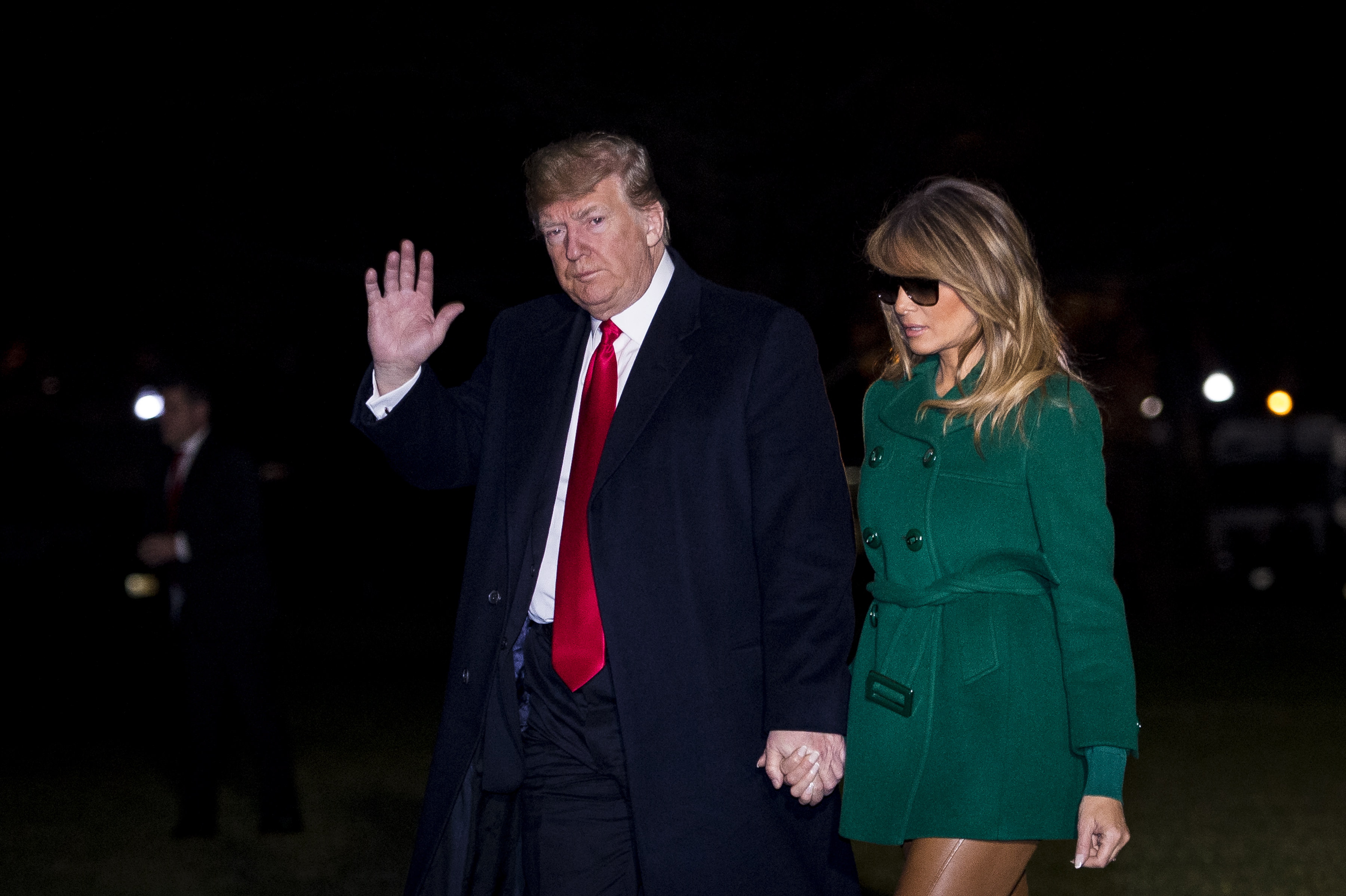 epa07250164 US President Donald J. Trump (L) and First Lady Melania Trump make their way across the South Lawn of the White House after returning on Marine One from their surprise trip to Al Asad Air Base in Iraq to visit troops, in Washington, DC, USA, 27 December 2018.  EPA/PETE MAROVICH