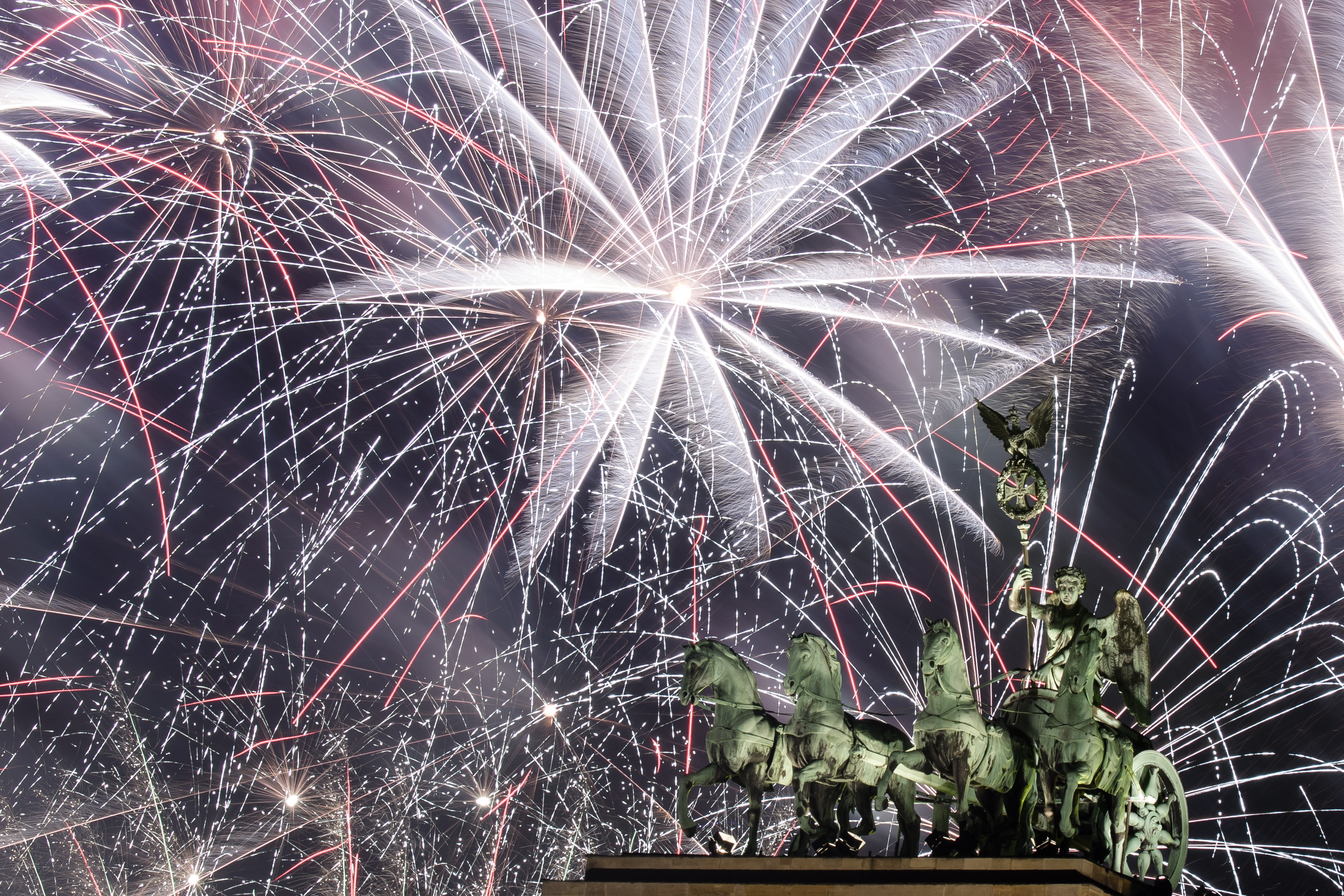 epaselect epa07255974 Fireworks illuminate the sky over the Quadriga statue of the Brandenburg Gate during New Year's Eve celebrations in Berlin, Germany, 01 January 2019.  EPA/CLEMENS BILAN