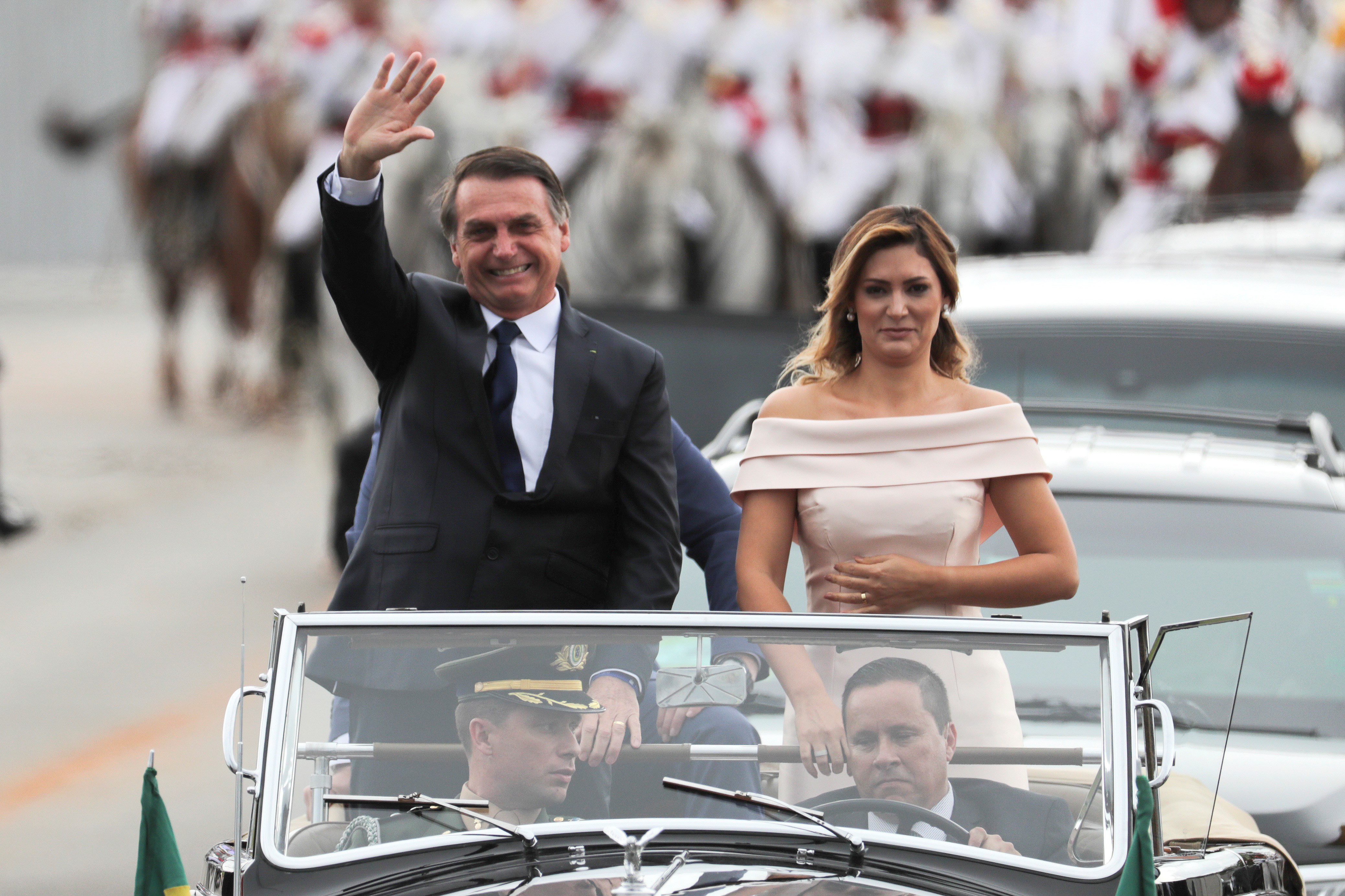 epa07257313 Brazilian President-elect Jair Bolsonaro (L) and wife Michele (R) head to the Planalto Palace on a Rolls Royce, for a ceremony in which Bolsonaro will receive the presidential band from his predecessor, Michel Temer, in Brasilia, Brazil, 01 January 2019 A far-right president leads the biggest Latin America democracy for first time since the end of military rule (1964-1985). Bolsonaro defeated candidate Fernando Haddad in the runoff, held last October, receiving 55 percent of the vote.  EPA/ANTONIO LACERDA