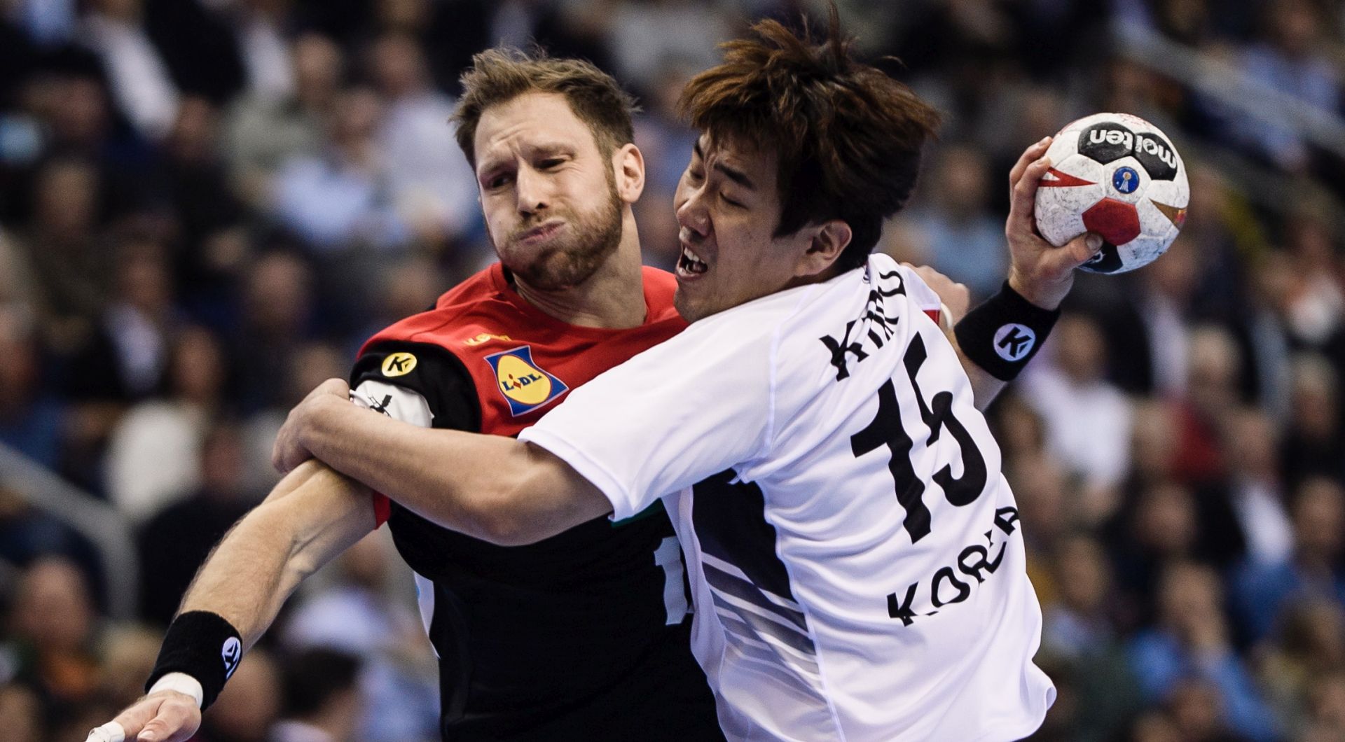 epa07273700 Steffen Weinhold of Germany (L) in action against Kim Dongmyung of Korea during the match between Germany and Korea at the IHF Men's Handball World Championship in Berlin, Germany, 10 January 2019.  EPA/CLEMENS BILAN