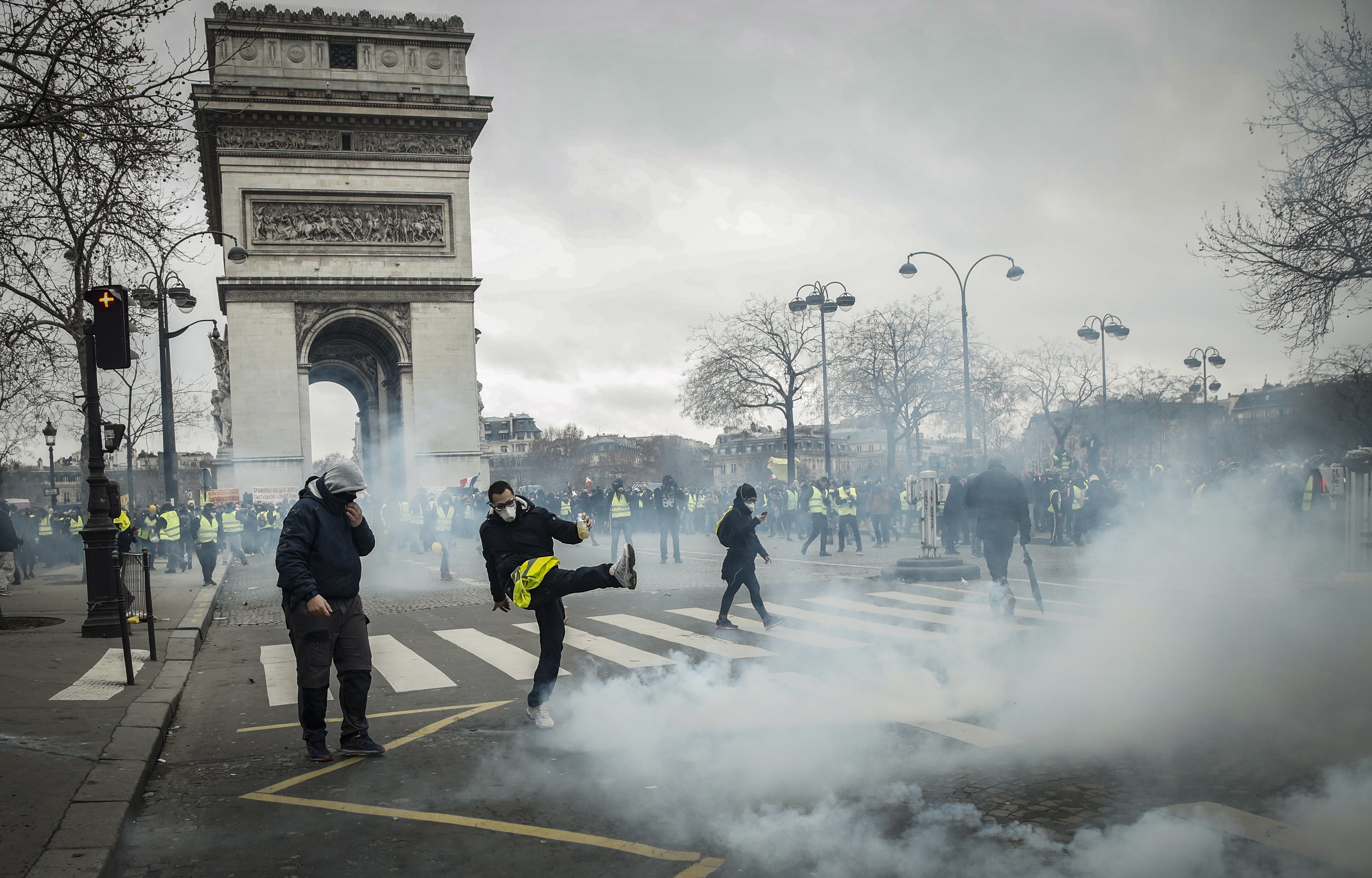 epa07277517 Tear gas engulfs the Place de l'Etoile, near the Arc de Triomphe, as protesters from the 'Gilets Jaunes' (Yellow Vests) movement take part in the 'Act IX' demonstration (the 9th consecutive national protest on a Saturday) in Paris, France, 12 January 2019. The so-called 'gilets jaunes' (yellow vests) is a grassroots protest movement with supporters from a wide span of the political spectrum, that originally started with protest across the nation in late 2018 against high fuel prices. The movement in the meantime also protests the French government's tax reforms, the increasing costs of living and some even call for the resignation of French President Emmanuel Macron.  EPA/YOAN VALAT