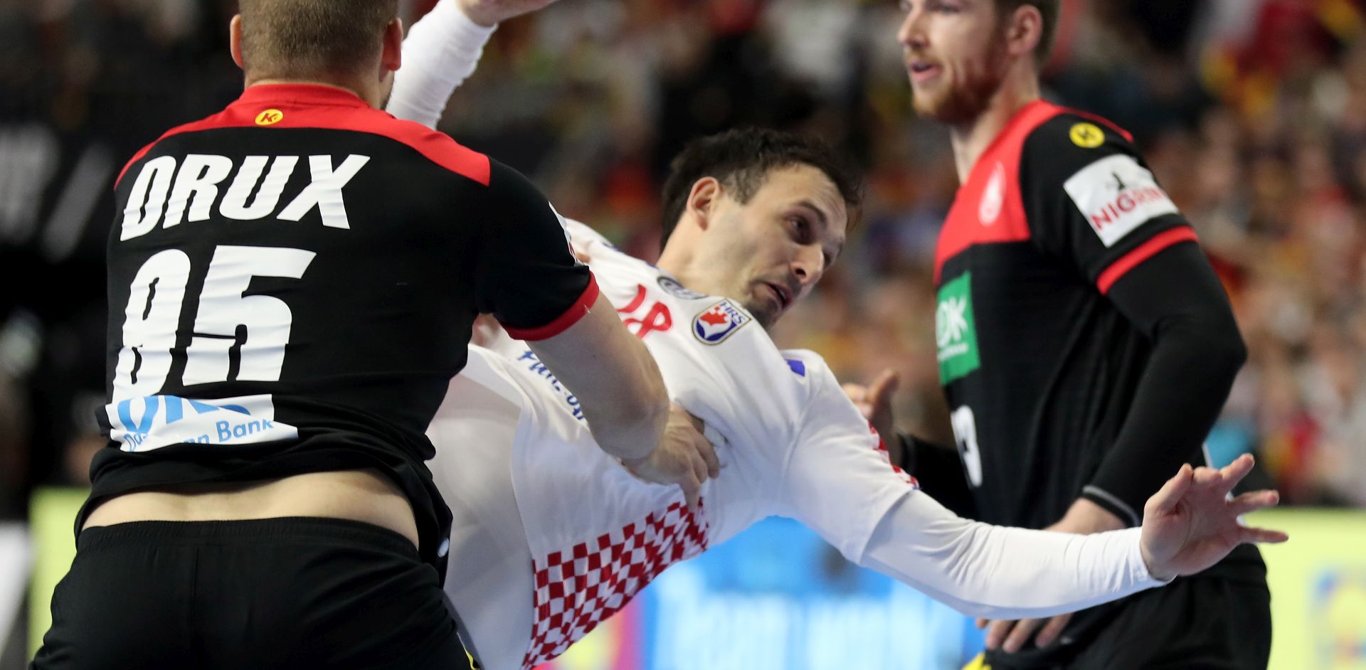 epa07307335 Igor Karacic (C) of Croatia in action against Paul Drux (L) of Germany during the main round group one match between Croatia and Germany at the IHF Men's Handball World Championship in Cologne, Germany, 21 January 2019.  EPA/FRIEDEMANN VOGEL