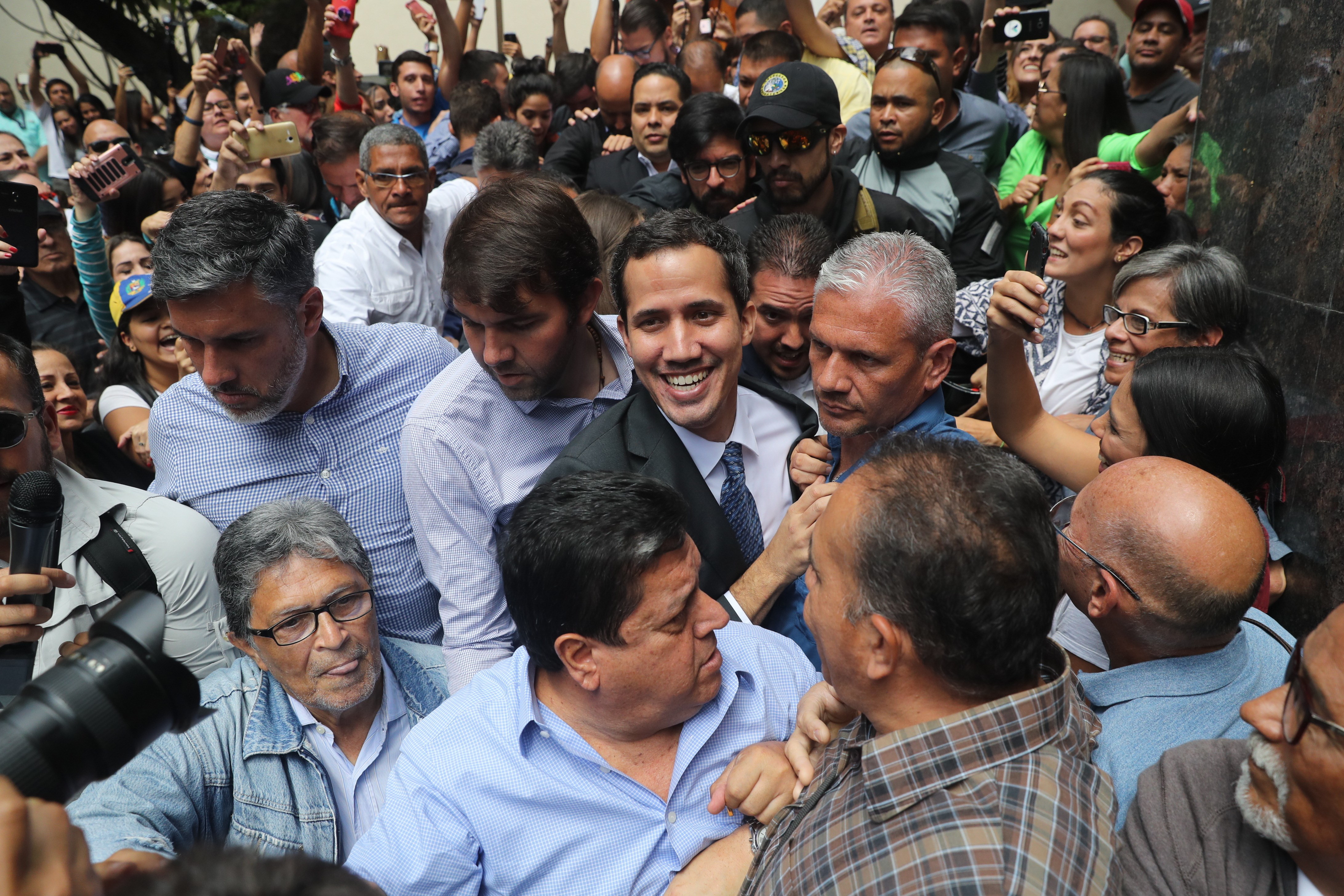 epa07319207 Head of the Venezuelan Parliament, Juan Guaido (C), upon his arrival to a public event with deputies in a square in the east of Caracas, Venezuela, 25 January 2018. Guaido, who two days ago announced that he assumed executive powers as interim president, asked on Friday for a minute of silence for the victims of 'the brutal repression'.  EPA/Miguel Guitérrez