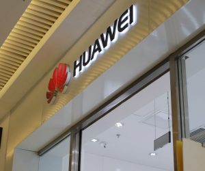 epa07328745 A Chinese woman walks out of from a Huawei store passing by an Apple poster in a shopping mall in Beijing, China, 29 January 2019. Officials from the US Justice Department, US Department of Homeland Security and US Commerce Department attended a news conference to announce criminal charges related to Chinese telecommunications conglomerate Huawei. US authorities announced a thirteen-count indictment charging four defendants; Huawei, two Huawei affiliates and Huawei's chief financial officer Meng Wanzhou.  EPA/WU HONG