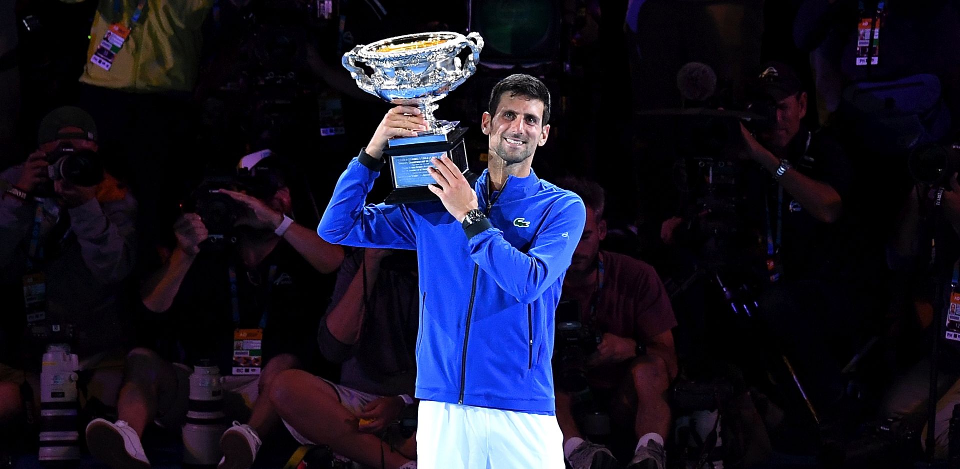 epa07324168 Novak Djokovic of Serbia raises the trophy after winning his men's singles final match against Rafael Nadal of Spain at the Australian Open Grand Slam tennis tournament in Melbourne, Australia, 27 January 2019.  EPA/ERIK ANDERSON EDITORIAL USE ONLY AUSTRALIA AND NEW ZEALAND OUT