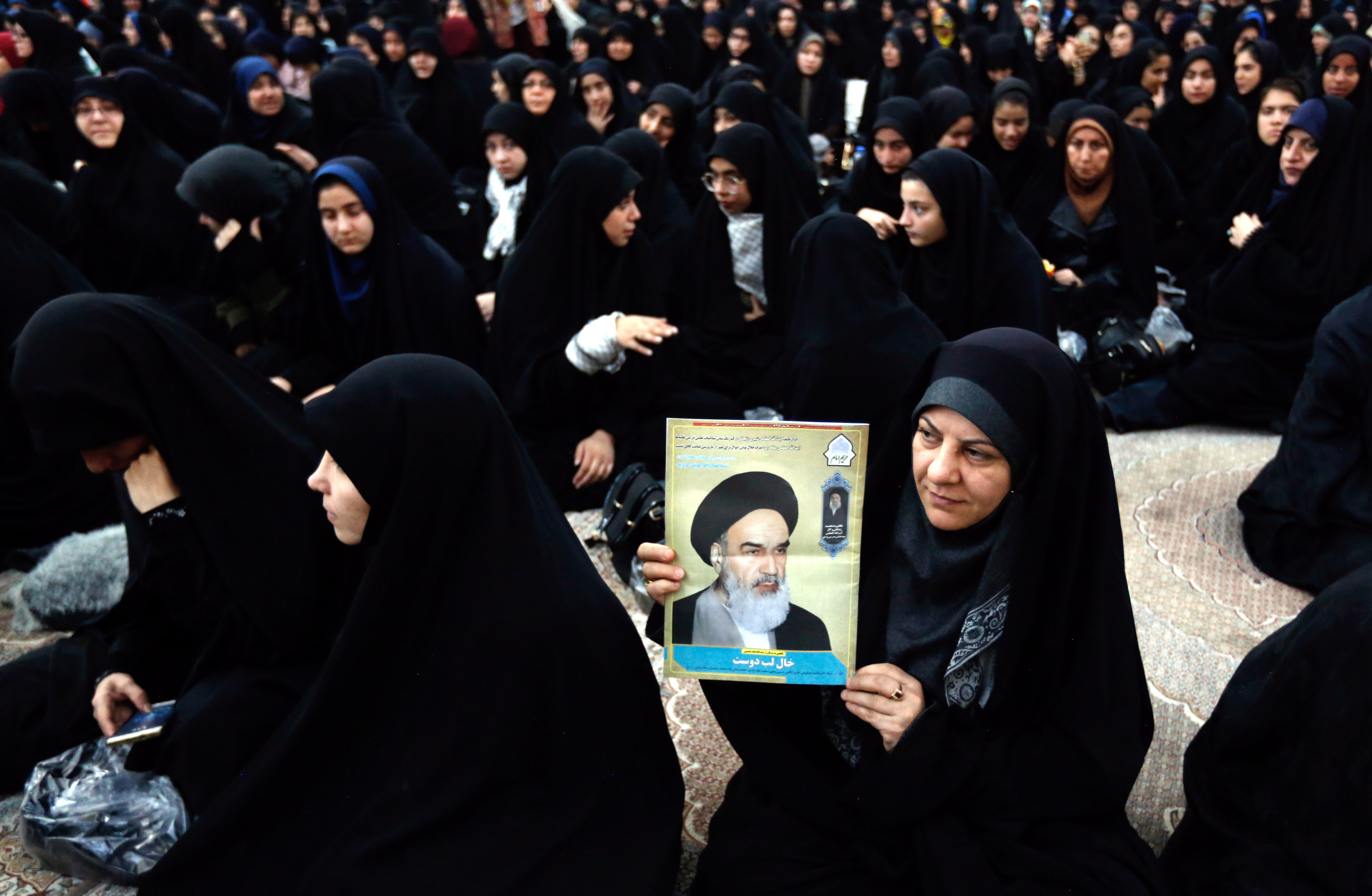 epa07335710 An Iranian woman holds a poster of Iran's late founder of the Islamic Republic, Ayatollah Ruhollah Khomeini on the occasion of the 40th anniversary of Khomeini's return from exile from Paris, at his mausoleum in southern Tehran, Iran, 01 February 2019. Iran will celebrate its 40th revolution anniversary on 11 February 2019.  EPA/ABEDIN TAHERKENAREH