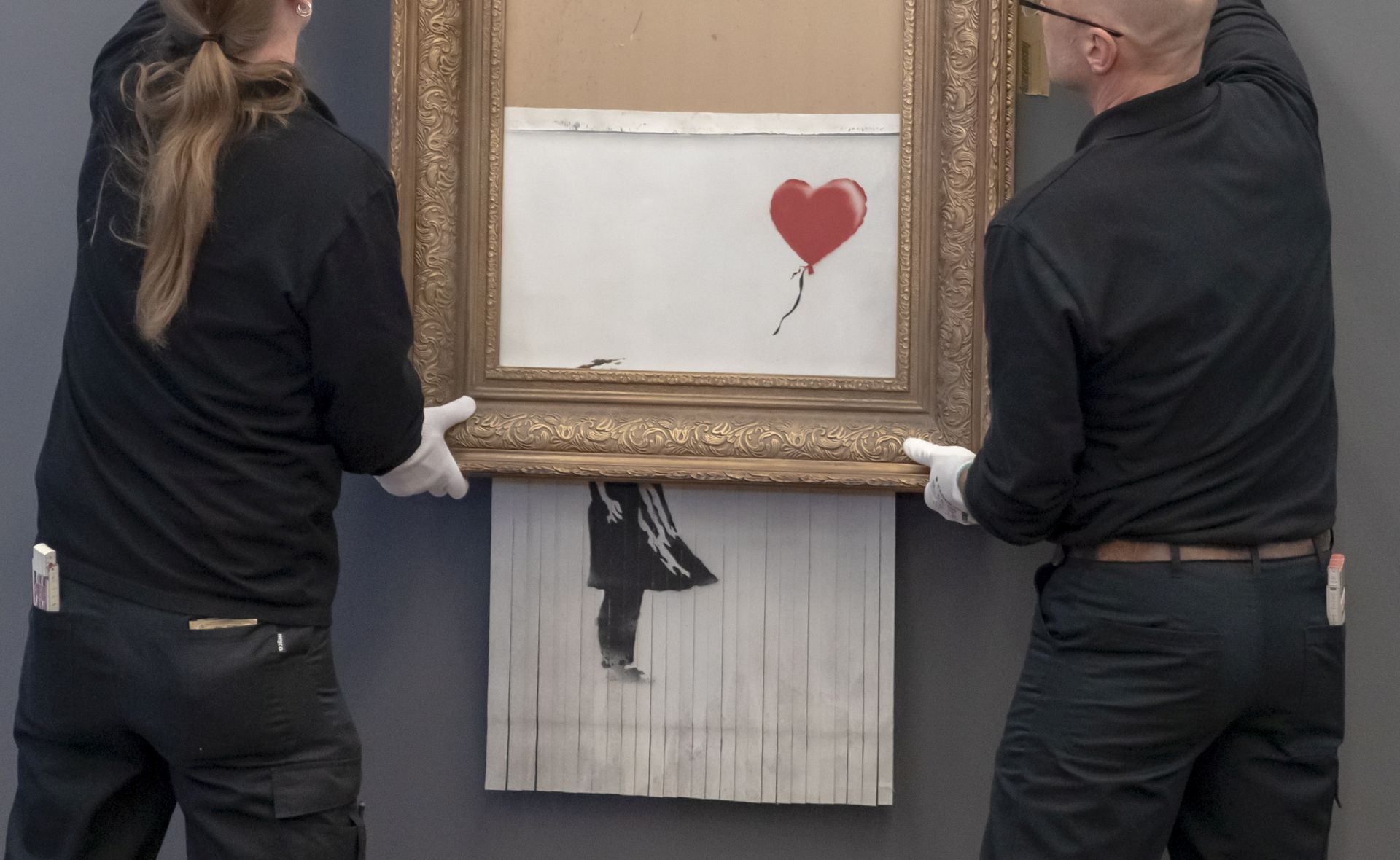 epa07342914 Museum employees hang Banksy's 'Love is in the Bin' artwork at the Frieder Burda Museum in Baden-Baden., Germany, 04 February 2019. The Frieder Burda Museum will be showing from 05 February 2019 to 03 March 2019 to the public for the first time the Banksy work 'Love is in the Bin', acquired by a European collector and auctioned off at Sotheby's in London.  EPA/RONALD WITTEK