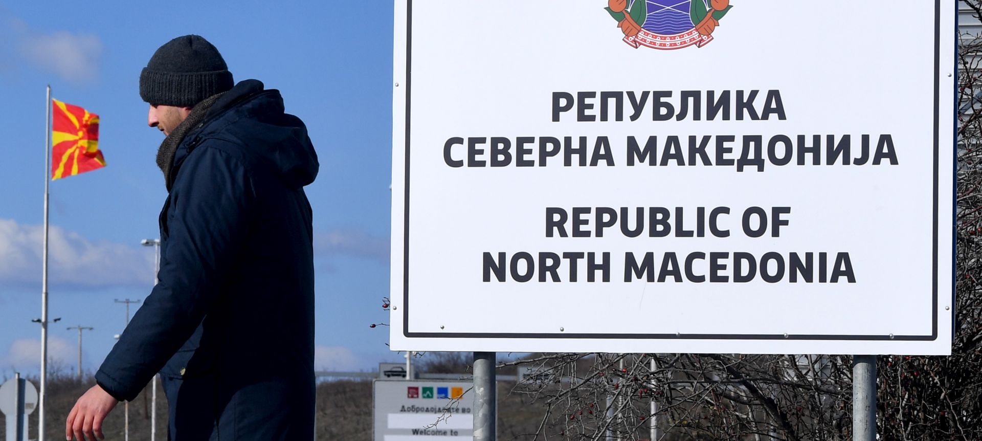 epa07366637 A man passes the new country name North Macedonia sign board, at the border crossing Bogorodica between North Macedonia and Greece on 13 February 2019. FYR of Macedonia Government is due change the name of country after ratification of the Protocol of the North Atlantic Treaty for the Accession of Republic of North Macedonia whereby Greece will approve the accession of its northern neighbor to NATO under its new name, as provided by the Prespes Agreement signed by Athens and Skopje.  EPA/GEORGI LICOVSKI