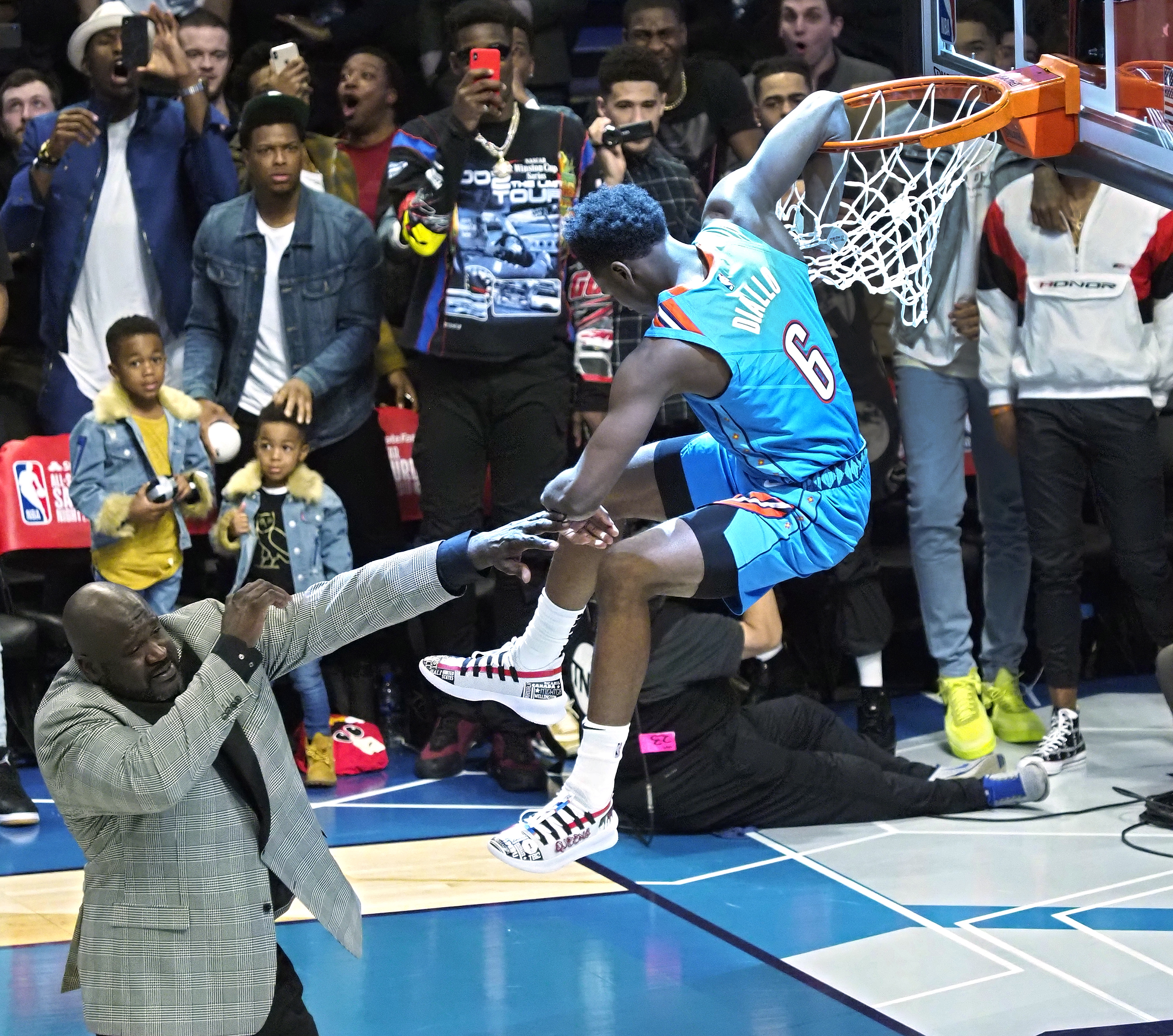 epa07376408 Oklahoma City player Hamidou Diallo (R) dunks the ball over the top of Shaquille O'Neal (L) in the Slam Dunk Contest during the All-Star Saturday Night on All Star Weekend at the Spectrum Center in Charlotte, North Carolina, USA, 16 February 2019.  EPA/JOHN G MABANGLO SHUTTERSTOCK OUT SHUTTERSTOCK OUT