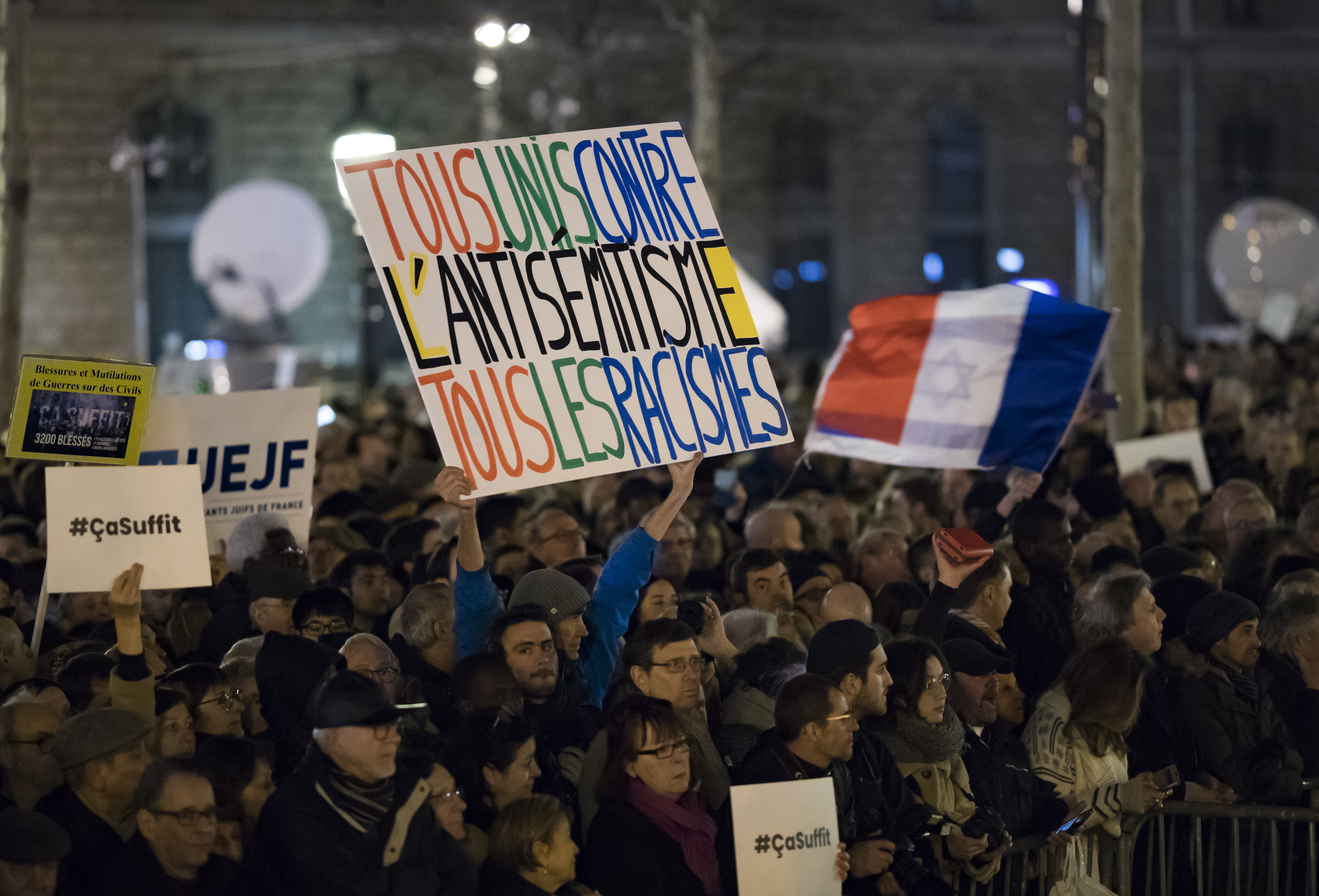epa07381710 People attend nation-wide rally to protest against antisemitism after media reports noted a recent sharp rise in anti-semitic acts across the country,  on the Place de la Republique in Paris, France, 19 February 2019. Sign reads 'All united against Antisemitism, all the racisms' French residents and public officials from across the political spectrum gathered for nationwide rallies against anti-Semitism following a series of anti-Semitic acts, including the swastikas painted on about 80 gravestones at a Jewish cemetery overnight.  EPA/IAN LANGSDON