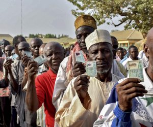 epa07389771 Nigerians display their voter cards as they line up to cast their ballots in the presidential elections in Abuja, Nigeria, 23 February 2019. Nigerians head to the polls to vote in the presidential and parliamentary elections after being delayed by one week by the Independent National Electoral Commission (INEC).  EPA/STR