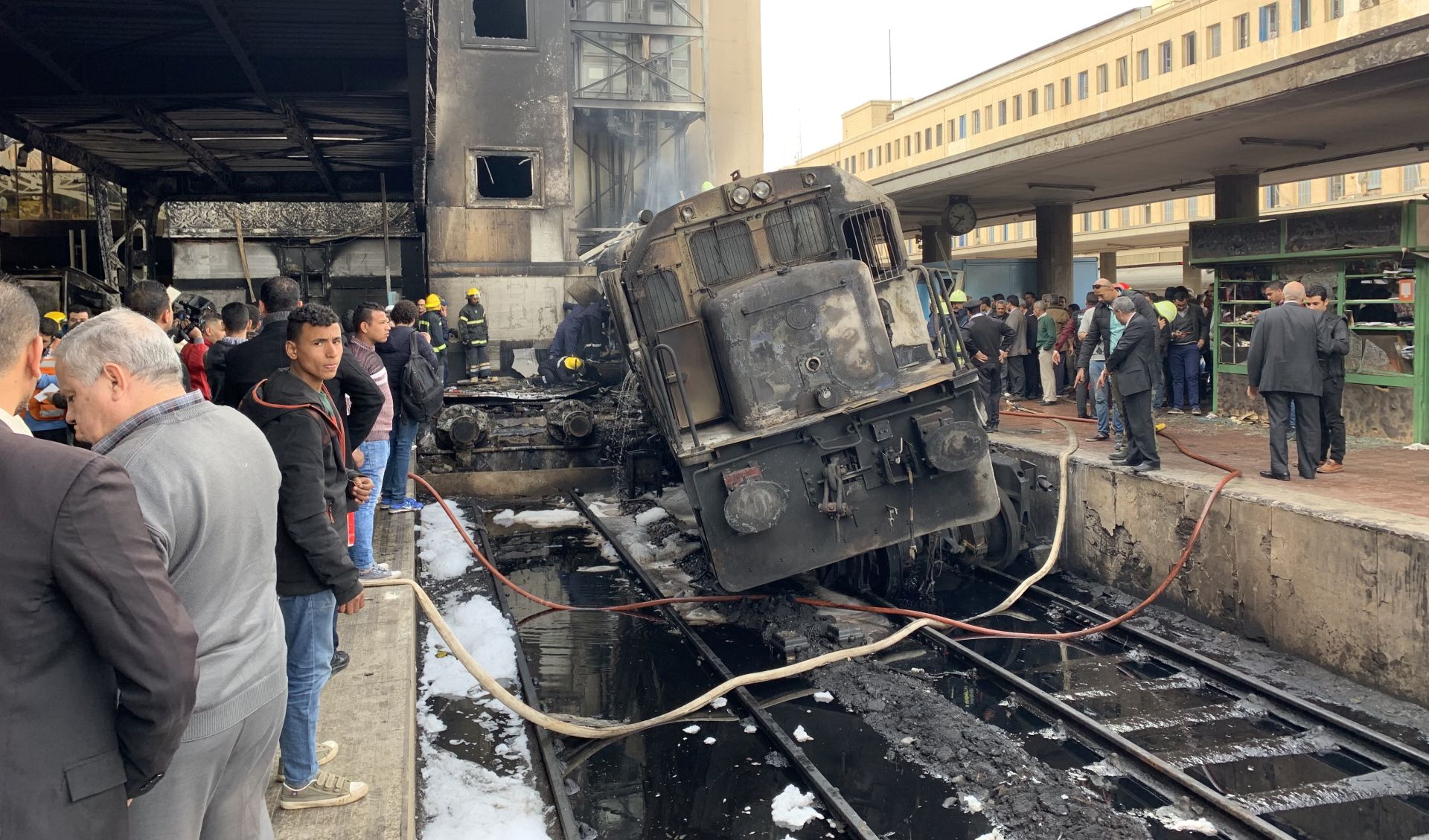 epa07400366 A destroyed train restst on tracks at the main train station in Cairo, Egypt, 27 February 2019. Local media reports state at least ten people died and 22 were injured after a large fire engulfed an area at the main train station, possible triggered by an explosion of a fuel tank of a passing train. It is feared the number of casualties could rise.  EPA/KHALED ELFIQI