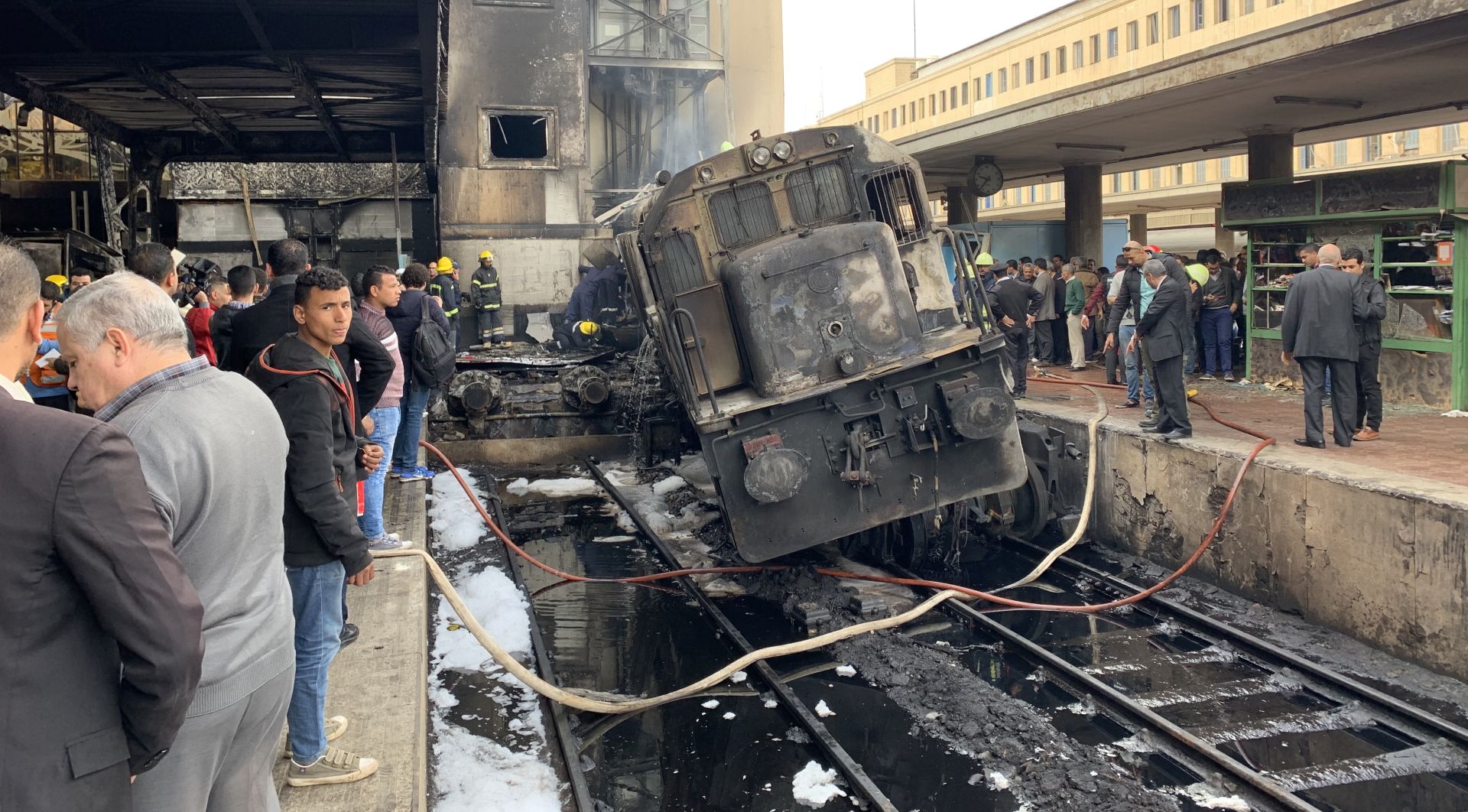 epa07400366 A destroyed train restst on tracks at the main train station in Cairo, Egypt, 27 February 2019. Local media reports state at least ten people died and 22 were injured after a large fire engulfed an area at the main train station, possible triggered by an explosion of a fuel tank of a passing train. It is feared the number of casualties could rise.  EPA/KHALED ELFIQI