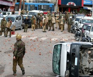 epa07371776 Jammu and Kashmir policemen stand near damaged vehicles during a protest against the terror attack that killed over forty Central Reserve Police Force (CRPF) personnel in Pulwama in Jammu, the winter capital of Kashmir, India, 15 February 2019. A curfew was imposed in parts of Jammu city following massive protests over the terror attack in Pulwama, according to the news reports more than 50 vehicles have been vandalised and eight vehicles set ablaze by the angry mob. At least 44 Indian paramilitary Central Reserve Police Force personnel were killed and several injured when a Jaish-e-Mohammed militant rammed an explosive-laden vehicle into a CRPF convoy along Srinagar-Jammu highway at Lethpora area in south Kashmir's Pulwama district on 14 February 2019, according local media reports.  EPA/JAIPAL SINGH