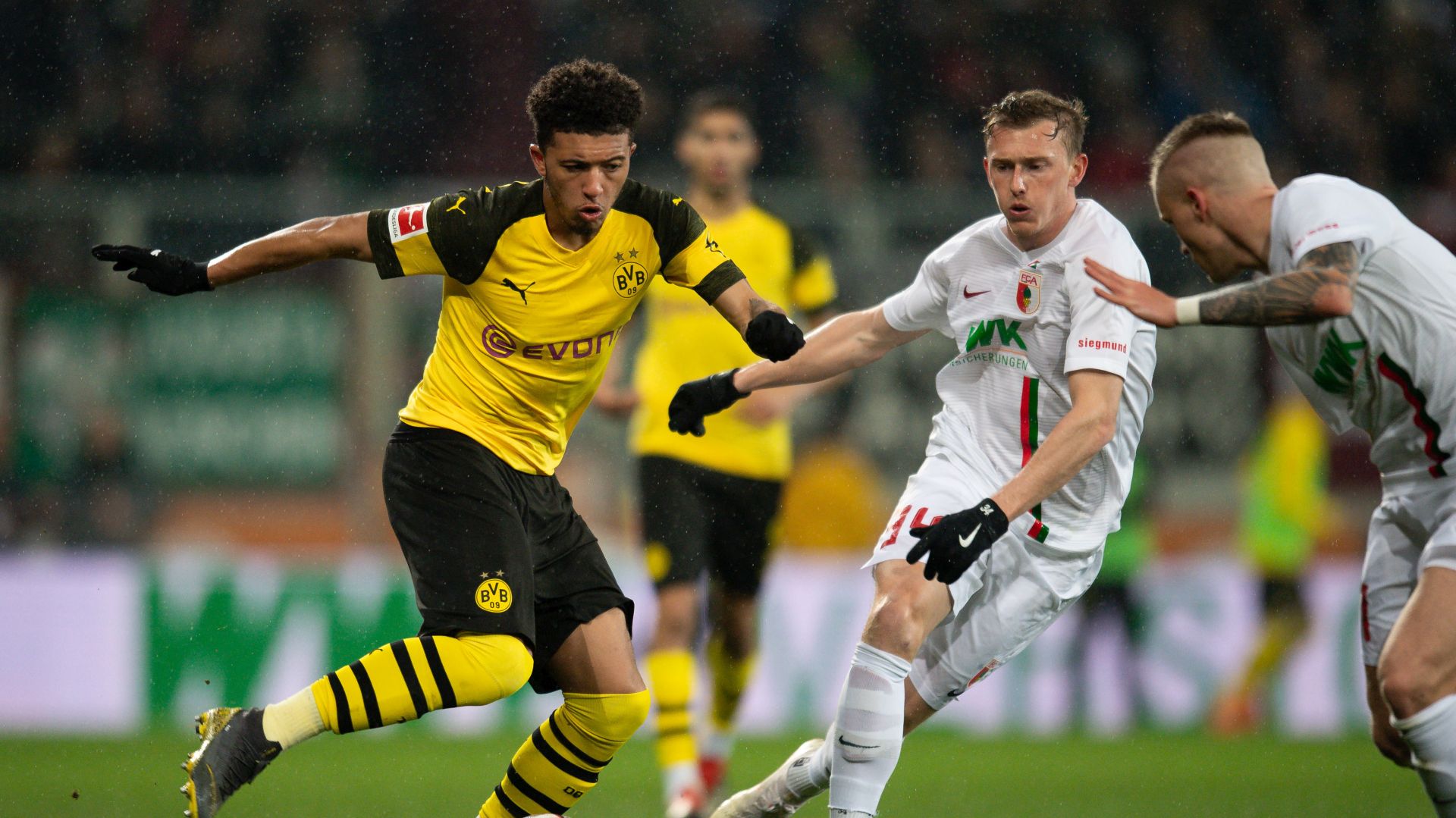 epa07407403 Jadon Sancho of Dortmund (L) in action with Georg Teigl of Augsburg during the German Bundesliga soccer match between FC Augsburg and Borussia Dortmund in Augsburg, Germany, 01 March 2019.  EPA/DANIEL KOPATSCH CONDITIONS - ATTENTION: The DFL regulations prohibit any use of photographs as image sequences and/or quasi-video.