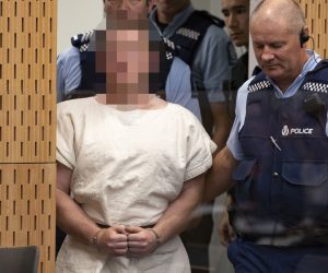 epa07441048 The man charged in relation to the Christchurch mosque massacre Brenton Harrison Tarrant (Pixelated) is lead into the dock for his appearance for murder, in the District Court, Christchurch, New Zealand, 16 March 2019. At least 49 people were killed by a gunman, believed to be Brenton Harrison Tarrant, and 20 more injured and in critical condition during the terrorist attacks against two mosques in New Zealand during Friday prayers on 15 March.  EPA/Martin Hunter / POOL NEW ZEALAND OUT
