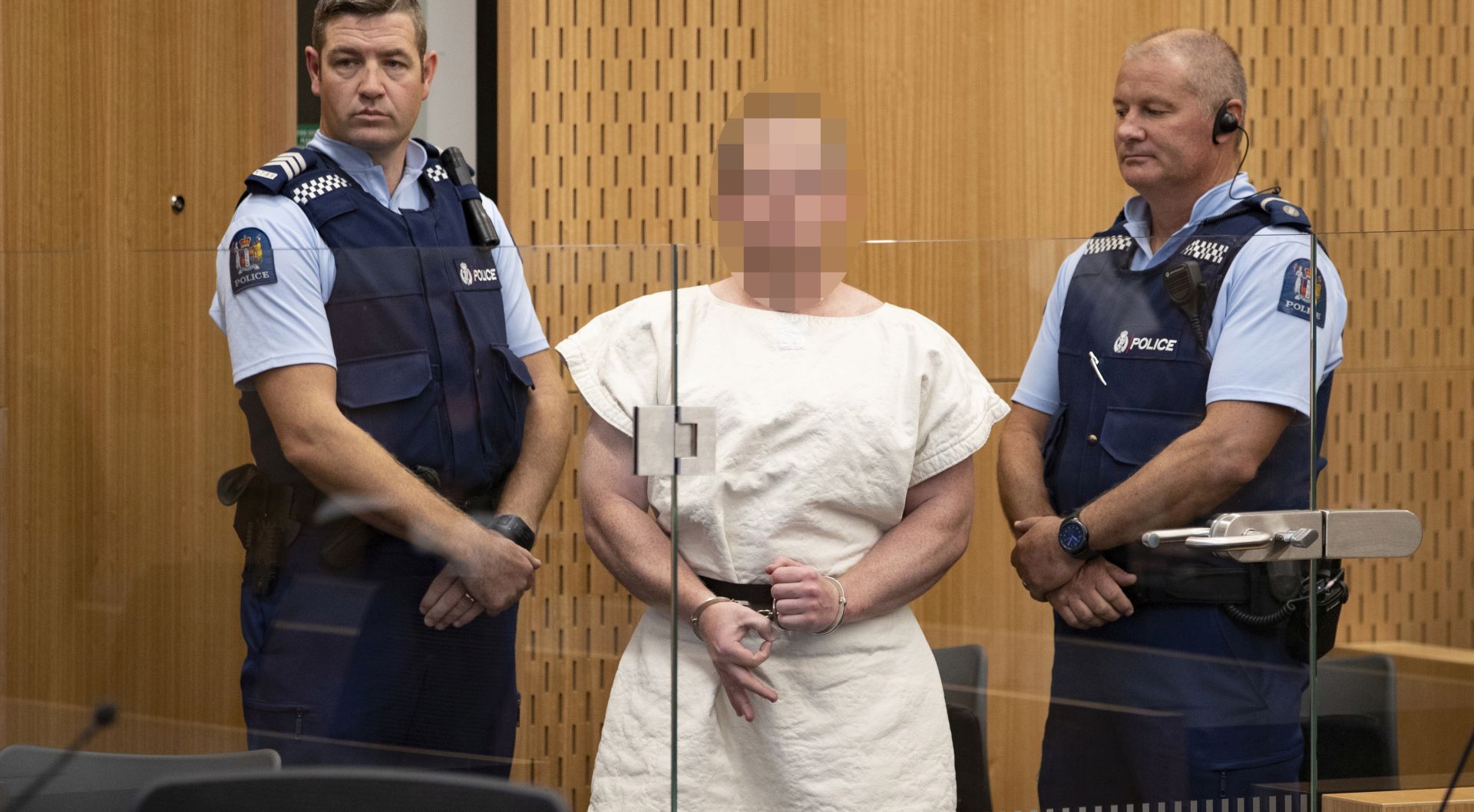 epa07441050 Brenton Tarrant (Pixelated) makes a sign to the camera during his appearance, on a charge of murder for Christchurch mosque massacre in the District Court, Christchurch, New Zealand, 16 March 2019. At least 49 people were killed by a gunman, believed to be Brenton Harrison Tarrant, and 20 more injured and in critical condition during the terrorist attacks against two mosques in New Zealand during Friday prayers on 15 March.  EPA/Martin Hunter / POOL NEW ZEALAND OUT