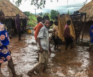 epa07446406 Inhabitants of Chiluvi, a village in central Mozambique, walk along a flooded and muddy street after Cyclone Idai and Floods that hit the region, in Nhamatanda, Mozambique, 13 March 2019 (Issued 18 March 2019). Chiluvo, together with Nhamatanda, Sofala, illustrates the tragedy that is experienced throughout the central region of Mozambique, especially in the provinces of Sofala and Manica, where there will already be between 73 and 84 confirmed deaths, according to official figures, leaving thousands in need of relief for remaining isolated in a flooded region.  EPA/ANDRE CATUEIRA BEST QUALITY AVAILABLE