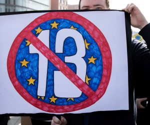 epa07458107 A protester holds a banner against Article 13 during the 'Save The Internet' demonstration in Berlin, Germany, 23 March, 2019. The demonstrators are protesting against article 11 and 13 to the  EU Copyright Directives, generally referring to the installation of 'upload filters' to monitor online content being loaded to large internet platforms, mainly social networks, thus prevent and report against misuse of copyrighted material. Those who oppose the articles claim that the implementation of them will cause  censorship and a blow to the freedom of speech and information, as the main claims in favor of them are that they will protect creators and the content they produce from being infringed.  EPA/OMER MESSINGER